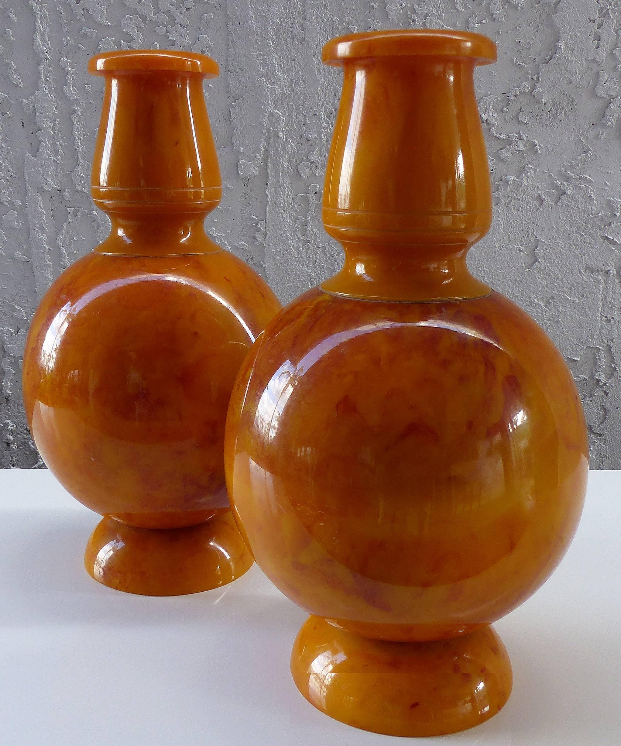Offered for sale is a very unusual and rare pair of butterscotch Bakelite urns probably intended as fireplace garniture pieces. The pair is in excellent condition with highly polished finishes. Measures: Base, 4.25