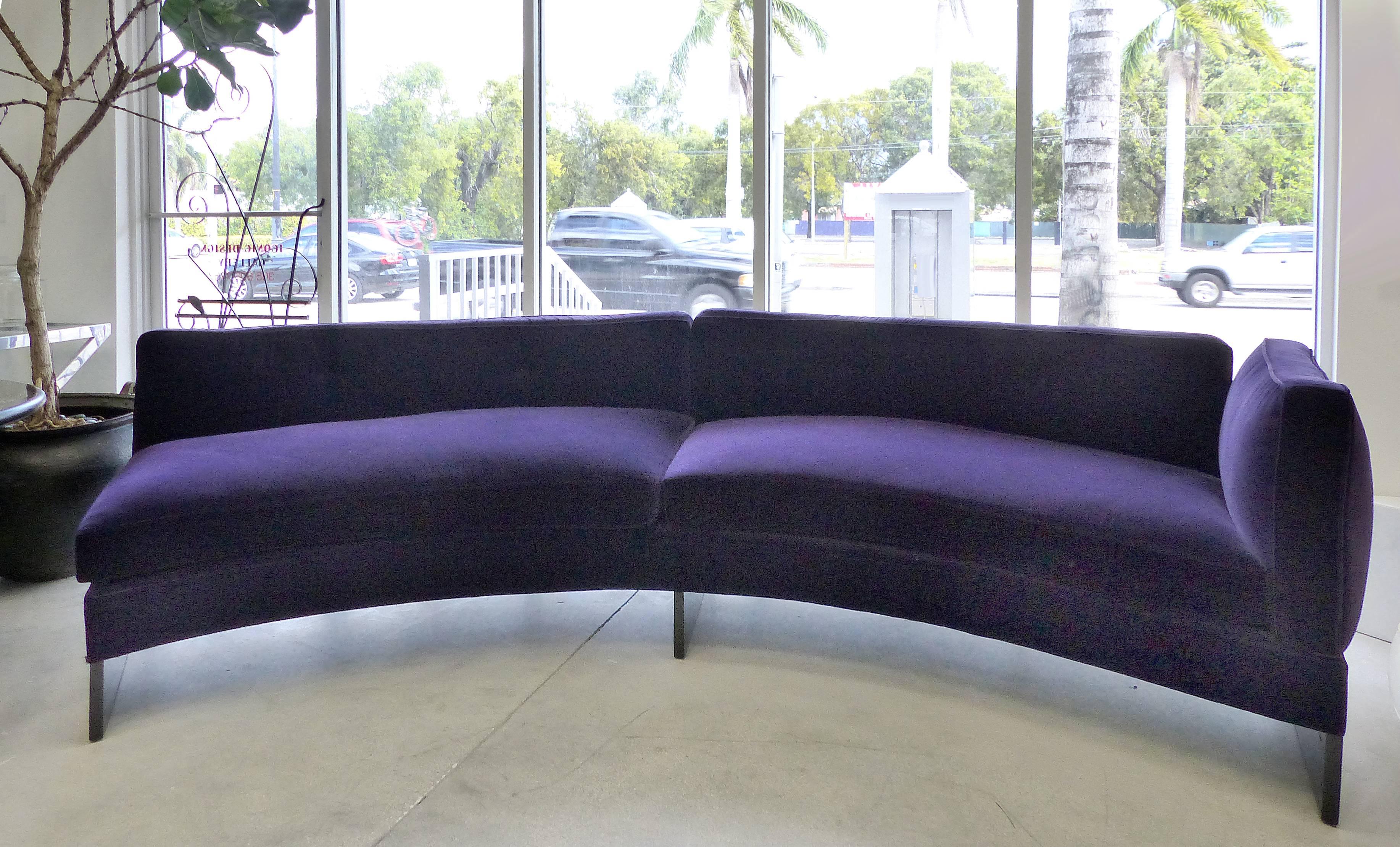 Offered for sale is an 11 foot long custom designed curved sofa in violet velvet which was commissioned by the previous owner from a NYC designer for a second home on Pine Tree Drive in Miami Beach. The sofa has one arm and is open on the opposite