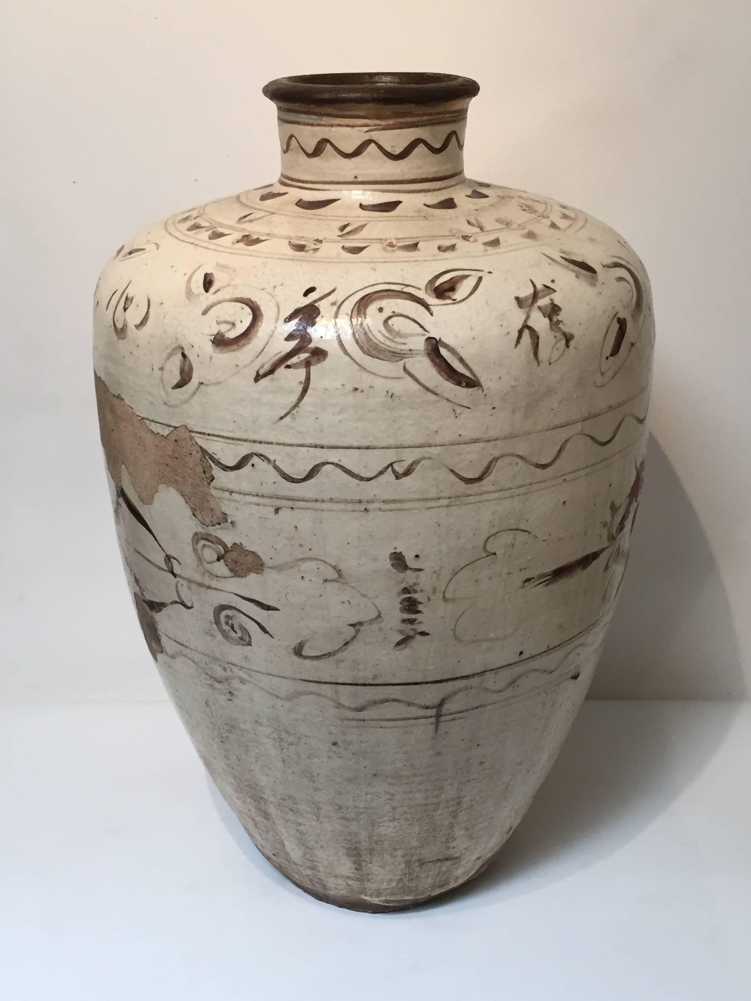 A large Chizhou storage jar from the Yuan dynasty (1271-1368).
A heavy cream-colored glaze as background, with abstract designs in a chocolate glaze. 
Measures: 26.5 