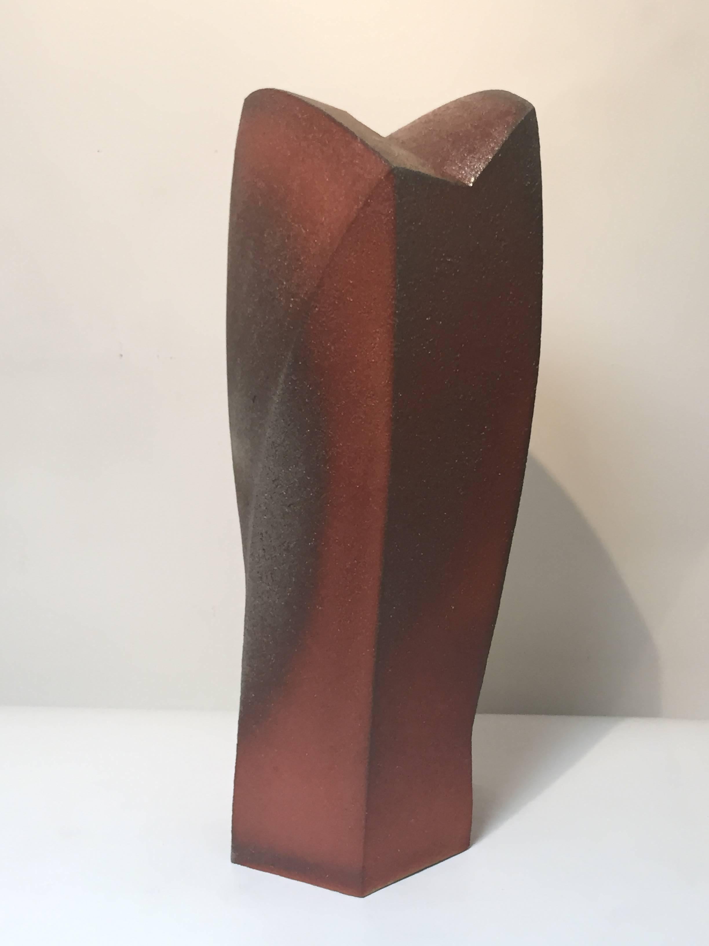 A large contemporary stoneware sculpture.
Hand built comprising five faceted sides. Each side distinct in shape, creating a bold, dynamic, and powerful result. The coarse burnt red clay casting shadows all-over the body.

Shunichi Yabe (1968- ) is