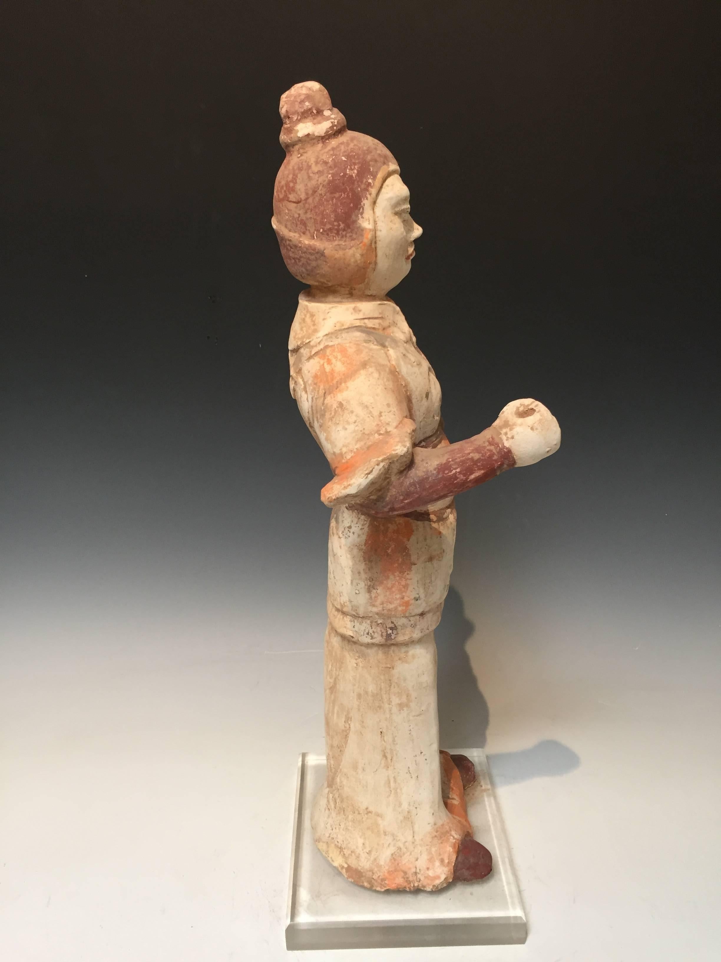 Standing tall with his right arm extended in a warrior pose, this impressive Tang dynasty pottery Attendant is adorned in military garb. Some original pigment still remains.
Measure: 23" tall x 6" deep x 6" wide.
