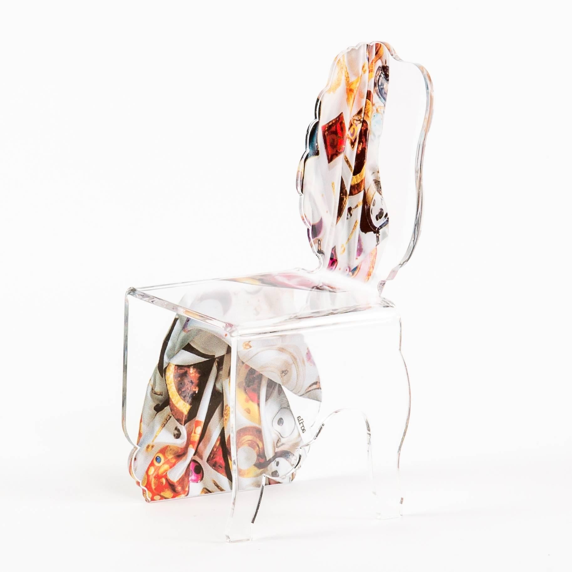 A contemporary 'Carlo Rampazzi' medallion acrylic chair from Paris, France with a sled base. This stunning chair is die-cut and bent into shape without the use of a single joint. It is highly resistant to wear, tear and scratches.