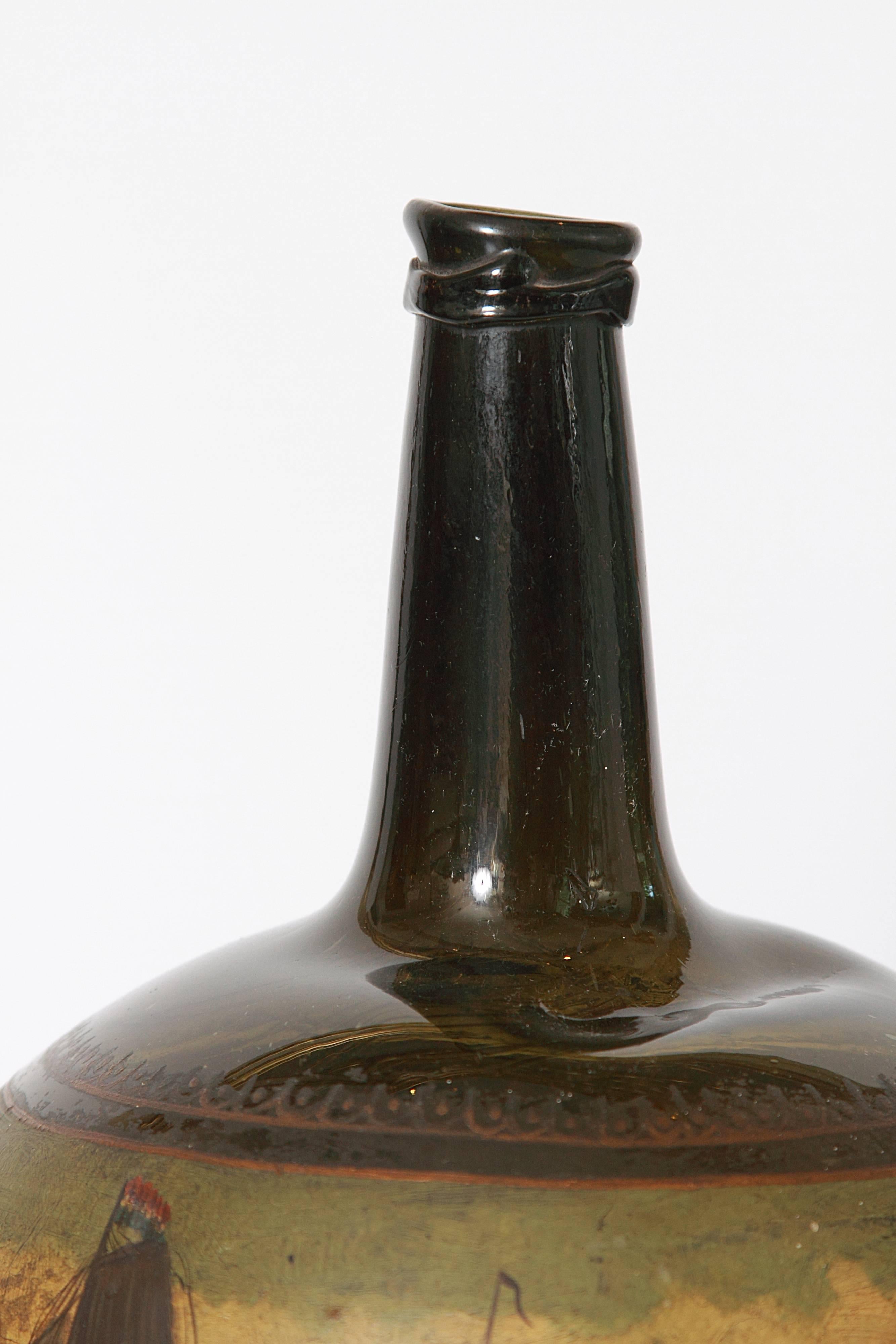 This Antique English 18th century painted glass onion wine bottle dates from circa 1680-1730. It is free blown and has a very unique and rare color. The form is an early bulbous shape. It has a high cone shape kicked up on underside and a tapering