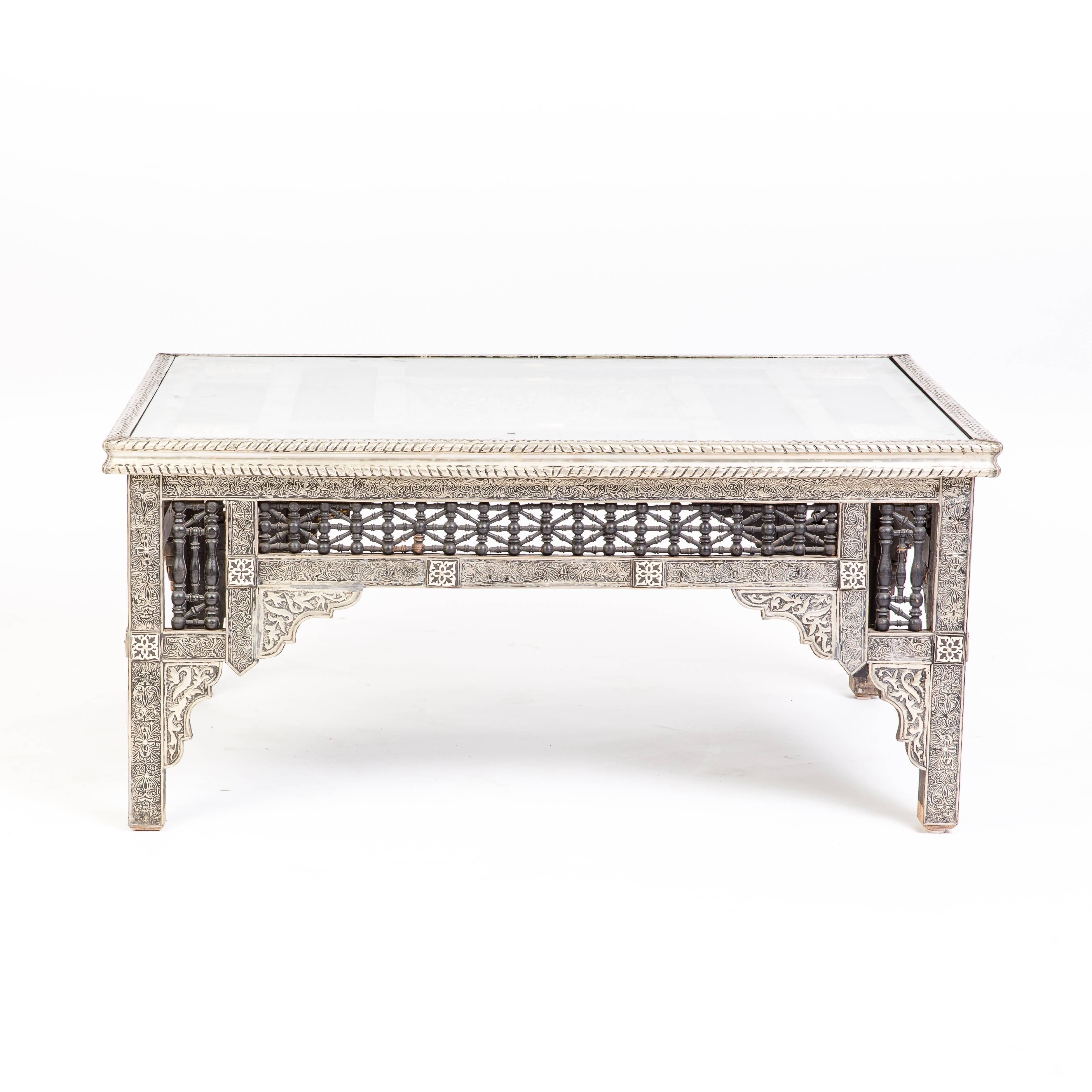 This is an exquisite silver inlaid coffee table with glass purchased from an artisan in Marrakech. This is a one of a kind piece with very intricate detailing. 

Measures: 45