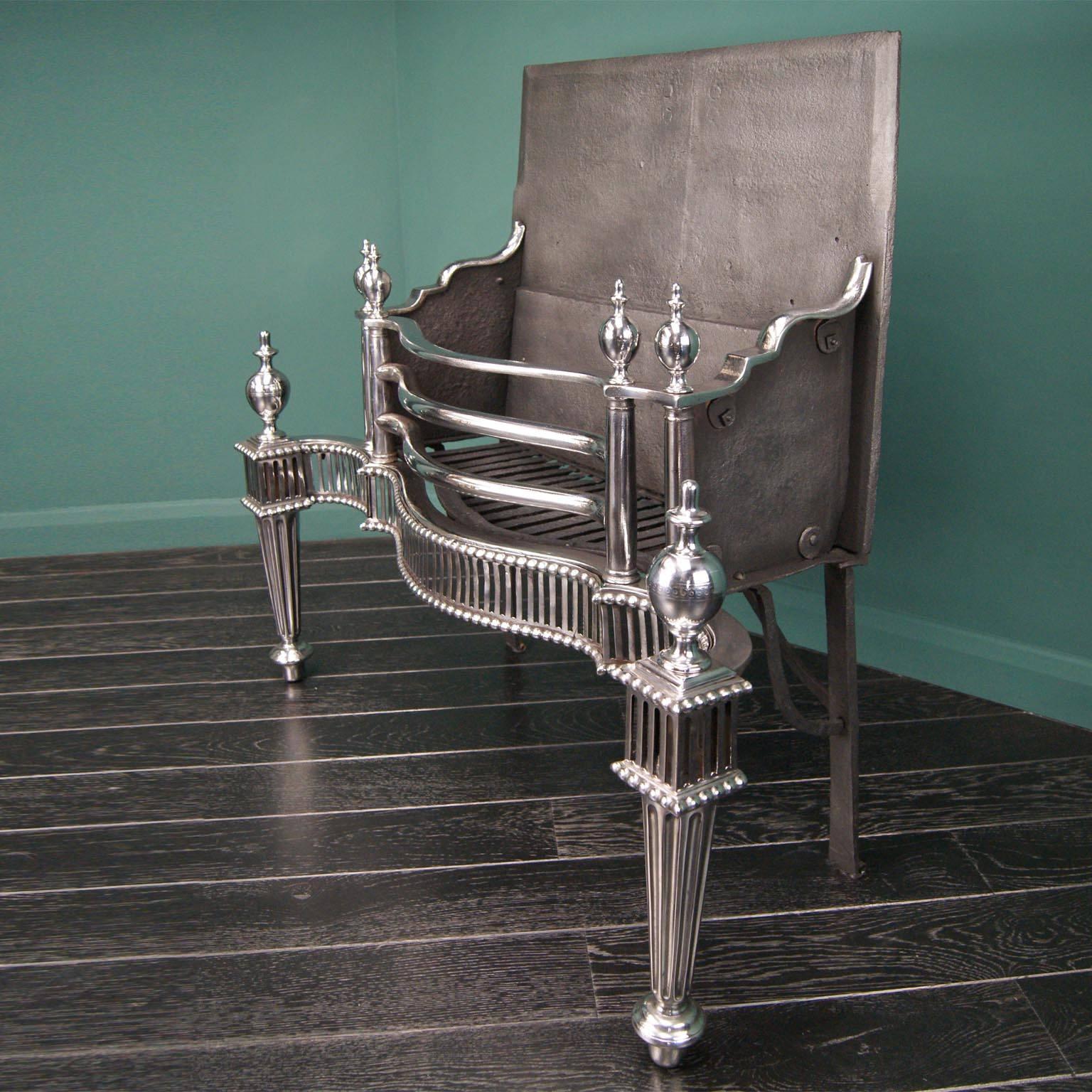 A magnificent English 18th century polished wrought iron dog grate. The serpentine basket front is flanked by double columns under bulbous vase finials. The fluted fret with beaded moulding is set between tapered column legs with fluted fillets.