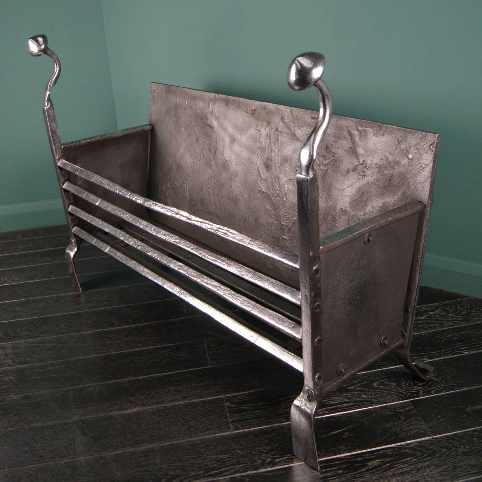 Large polished wrought iron 18th century fire basket with solid square fire bars, flared feet and wrought finials. Restored.
