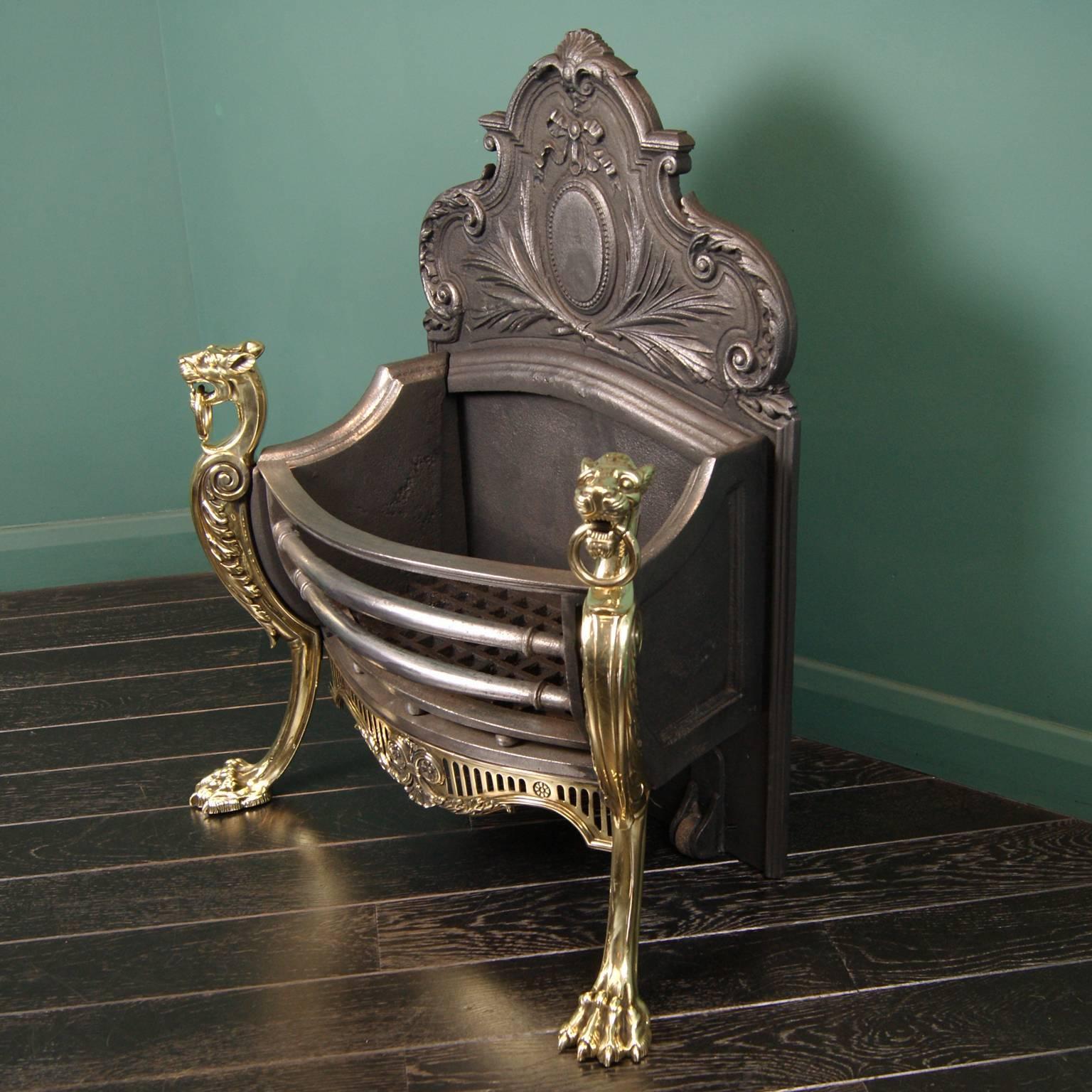 A 19th century brass and cast iron fire grate. The front basket with round fire bars set on sphere detail, is flanked by brass panthers. The ornate back plate with central oval detail and roller wheels. There is a picture of an identical grate at