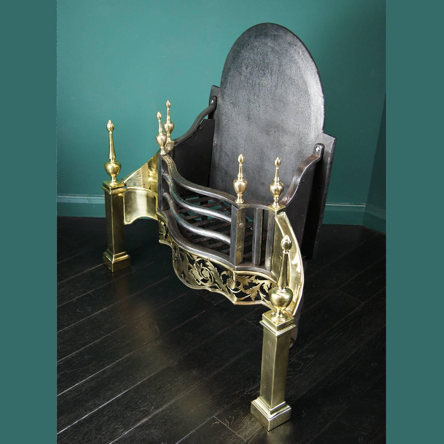 A large brass and wrought iron fire grate with an intricate pierced fret plate. Central fish detail is replicated with the engraving on brass wings. Additional engraving detail to legs and urns. Rivet-work grill and a shaped backplate,
circa 1840.