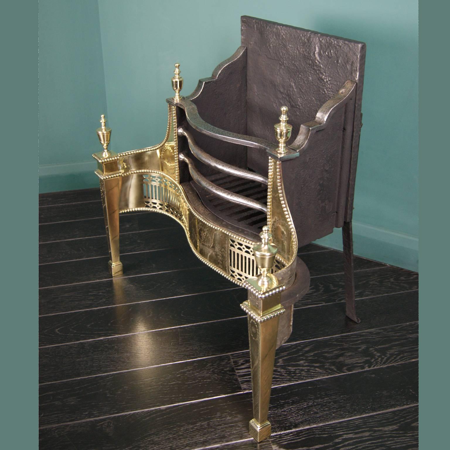 An English brass and wrought dog grate by Thomas Elsley. The pierced ornate fret is set between square tapered legs. Fine engraving detail to wings, fret and legs. Shaped wrought fire-bars, fire grill and square fire back,
circa 1890.