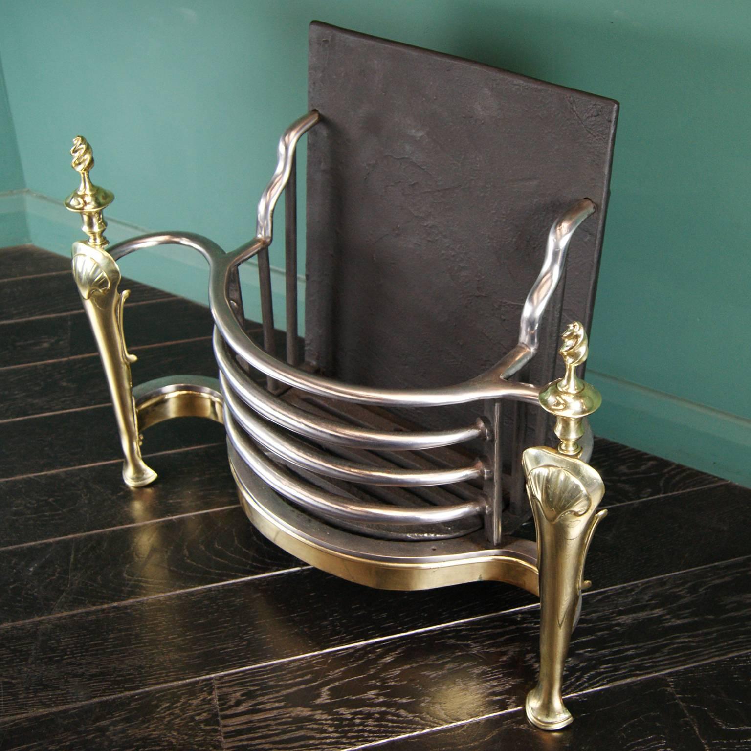 An elegant 19th century English brass and wrought-iron fire basket in the Queen Anne style, with cabriole legs, twist-top finials and a brass apron.