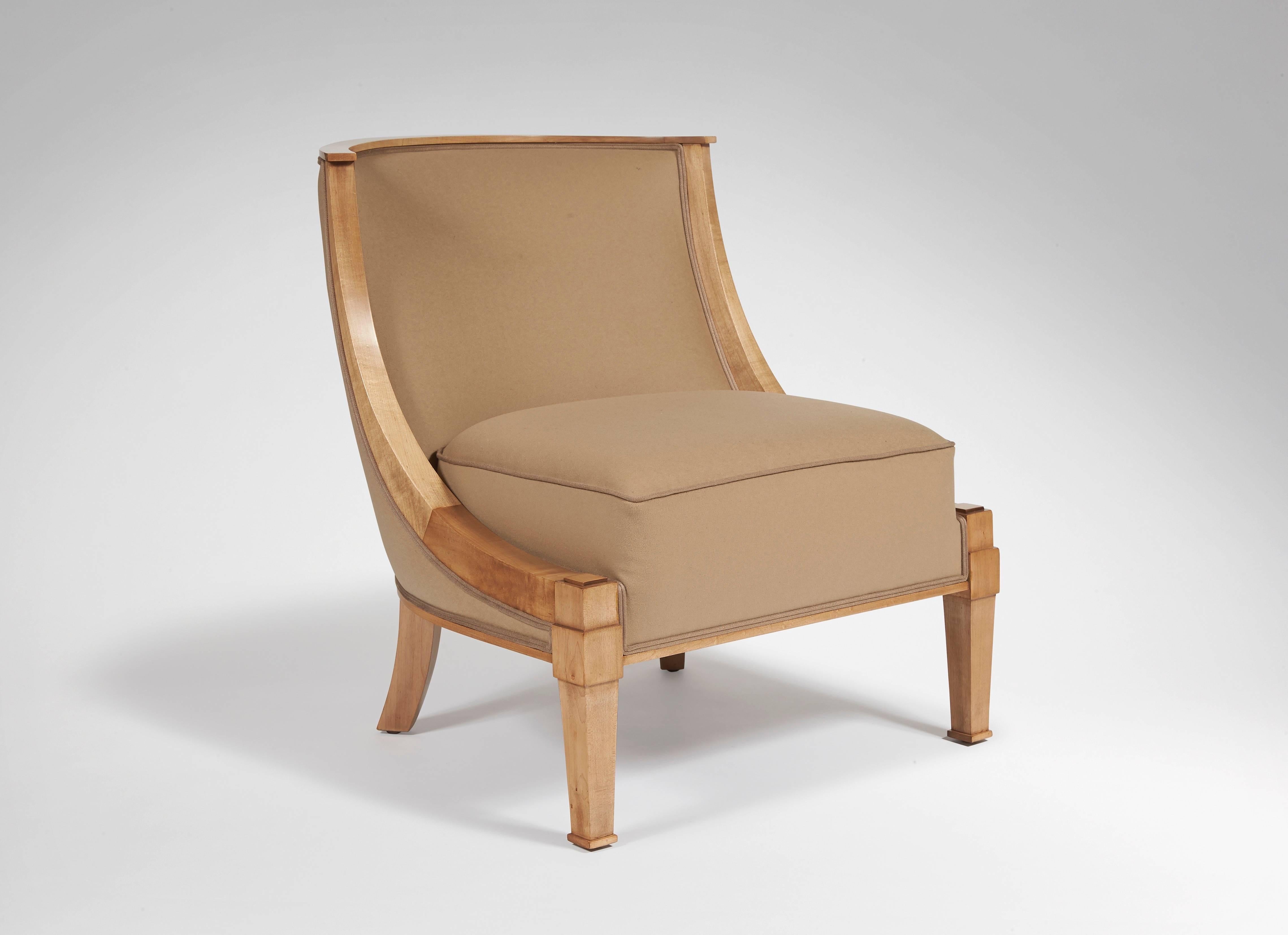 Fireside chair in the antique style in sycamore, the front legs crowned with capitals, ending with squared hoof, the back sword legs, gondola backrest, circular arcs armrests, covered with beige fabric.