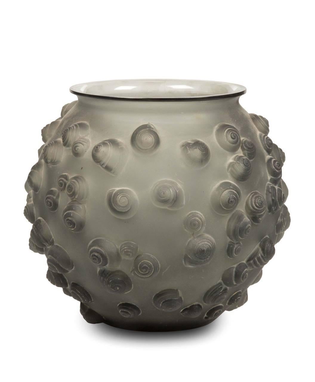 "Palissy" vase in grey blown and moulded opalescent glass. The decor made up with snails in relief. Signed.

History
The model created the 12th, November 1926, in the catalogs of 1928 and 1932, erased of the catalog in 1938 and not