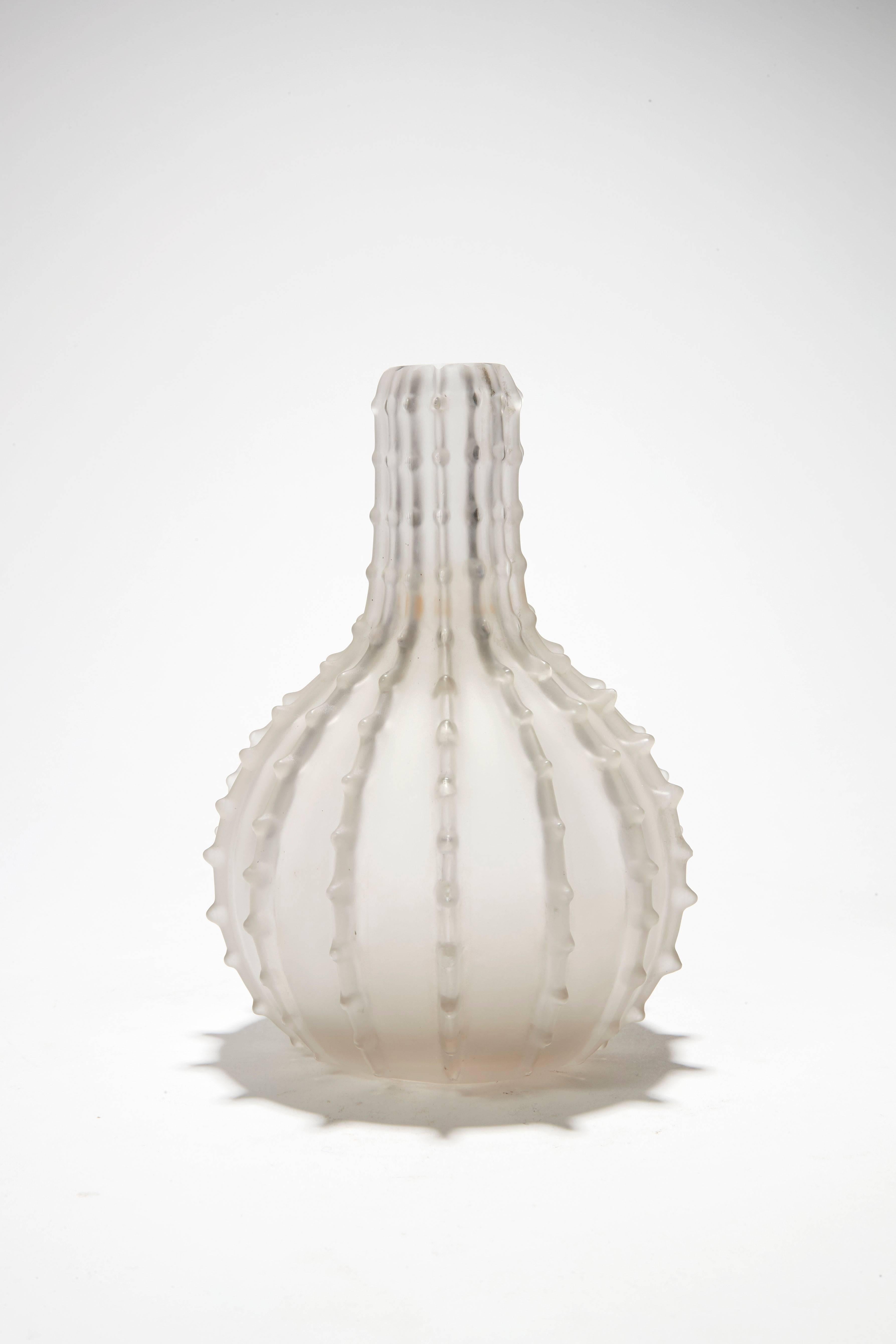 A circular-shaped "Dentelé" vase with a high neck, in white blown and moulded satined glass. The decor made up with vertical serrated lines. Signed.

Origin:
Private collection, Italia.

History:
The model created in 1912, in the