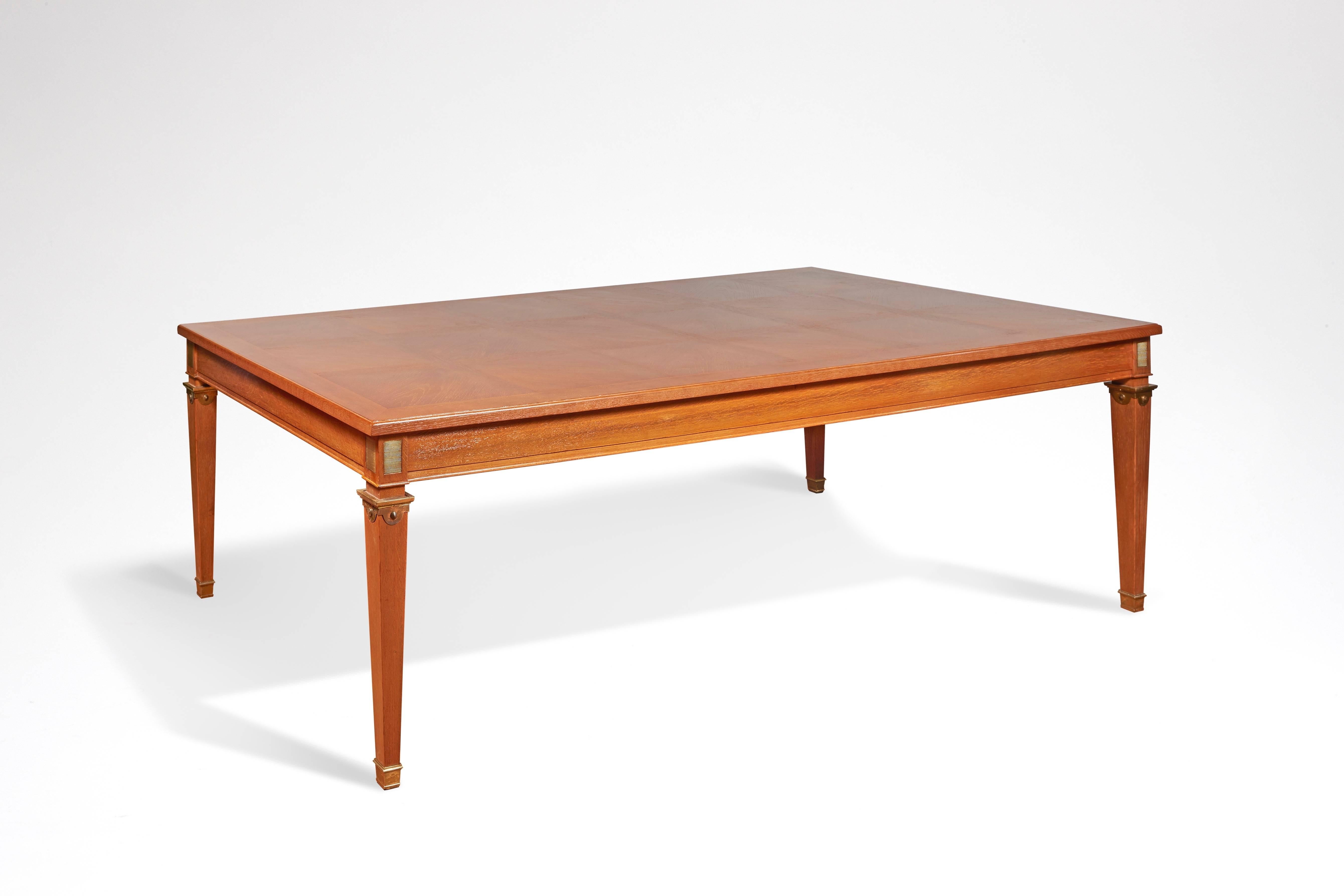 Réalisée en chêne cérusé patiné, elle présente un plateau rectangulaire, des angles latéraux ornés de plaques en laiton azuré et des pieds fuselés encastrés en haut et en bas par des éléments en laiton.

Mobilier créé par André Arbus dans les années