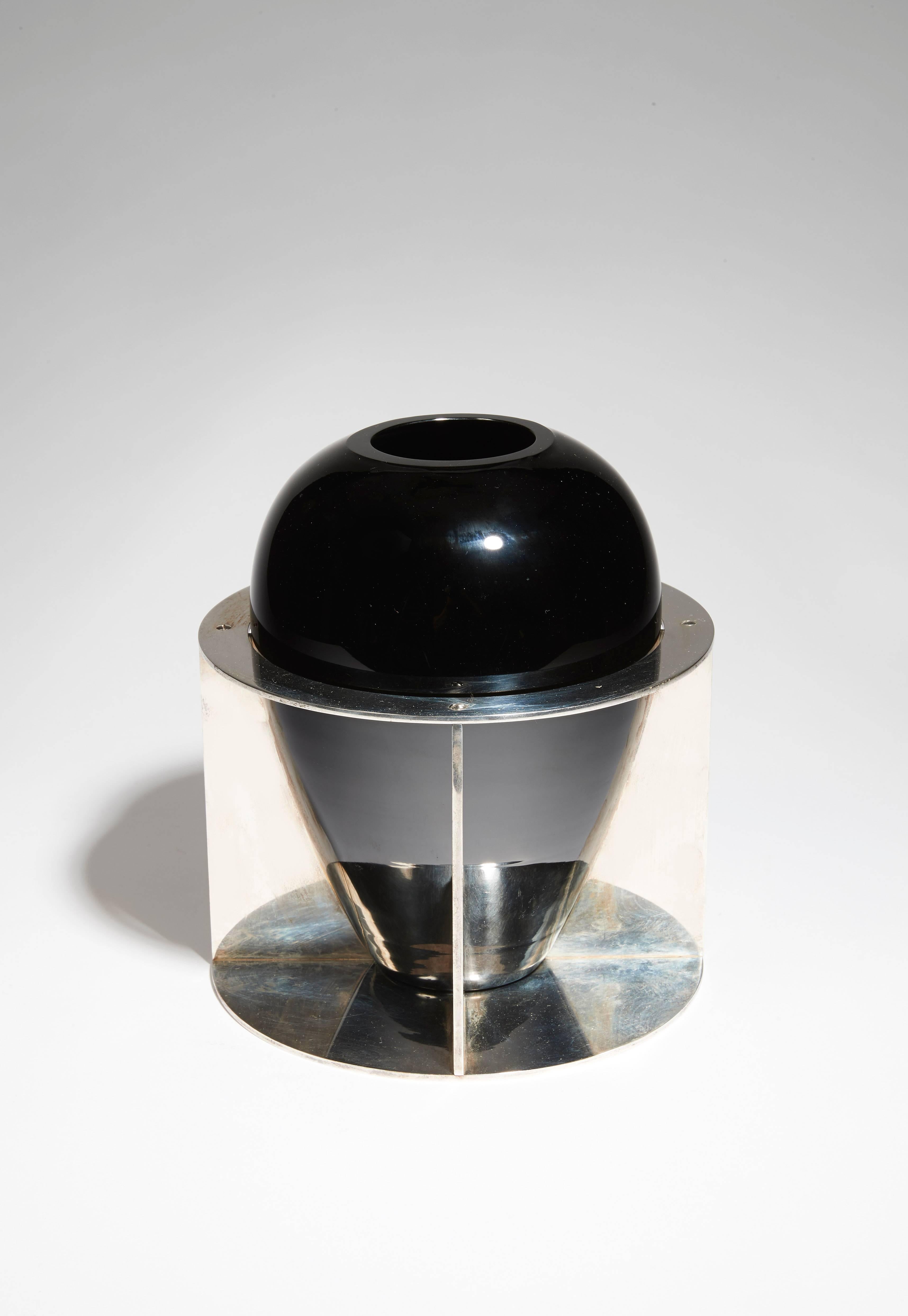 En verre noir opalin basé sur une structure en métal nickelé de forme circulaire avec des lames.

Signé avec le cachet 