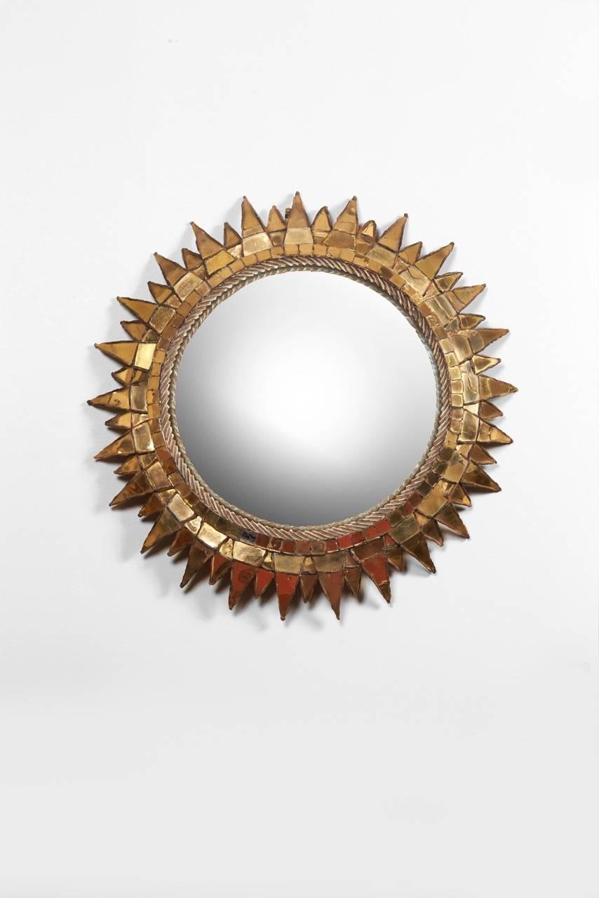 A Circular convex mirror in talosel and gold mirror. Signed 