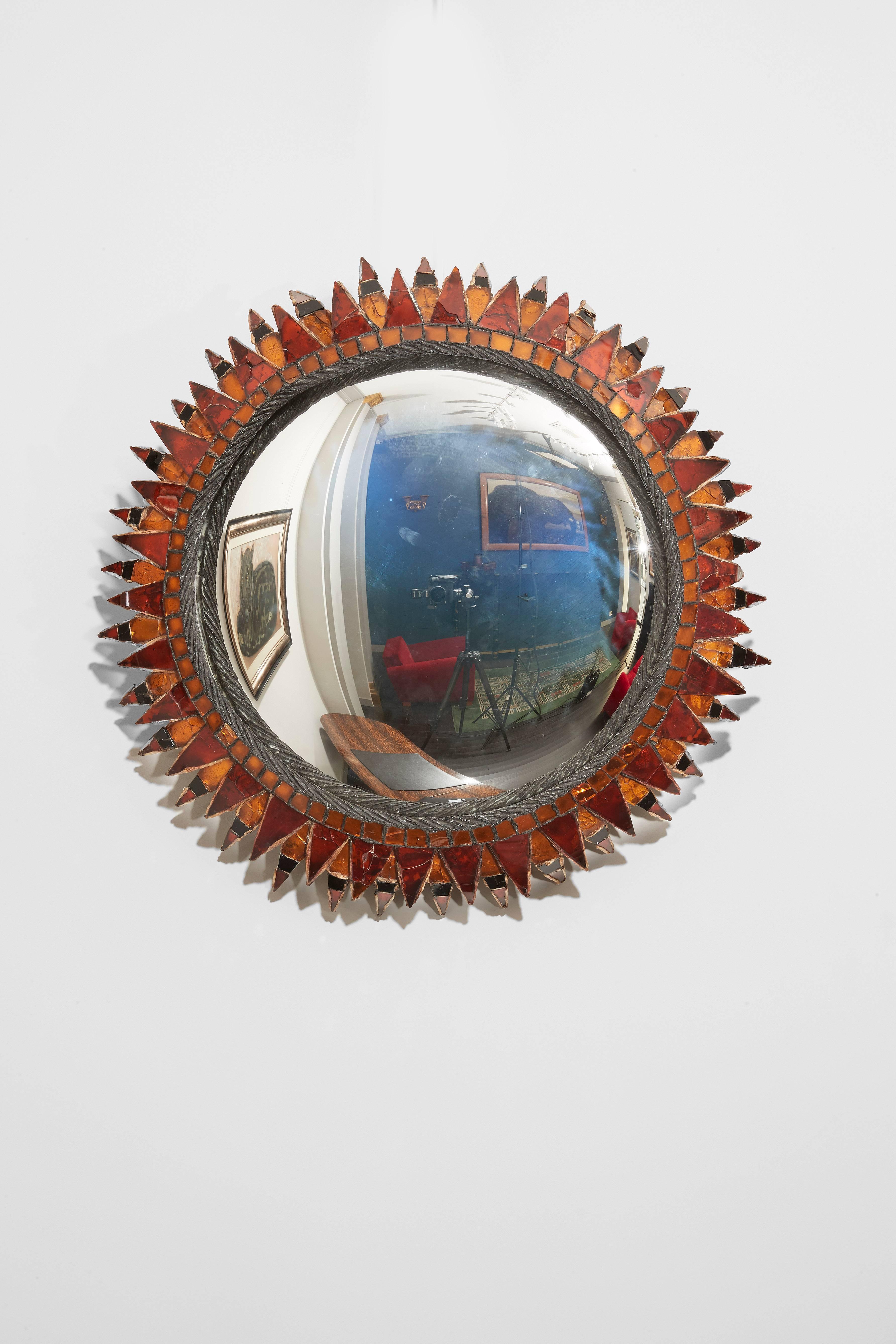 A Circular convex mirror in talosel and orange, black and red mirror.