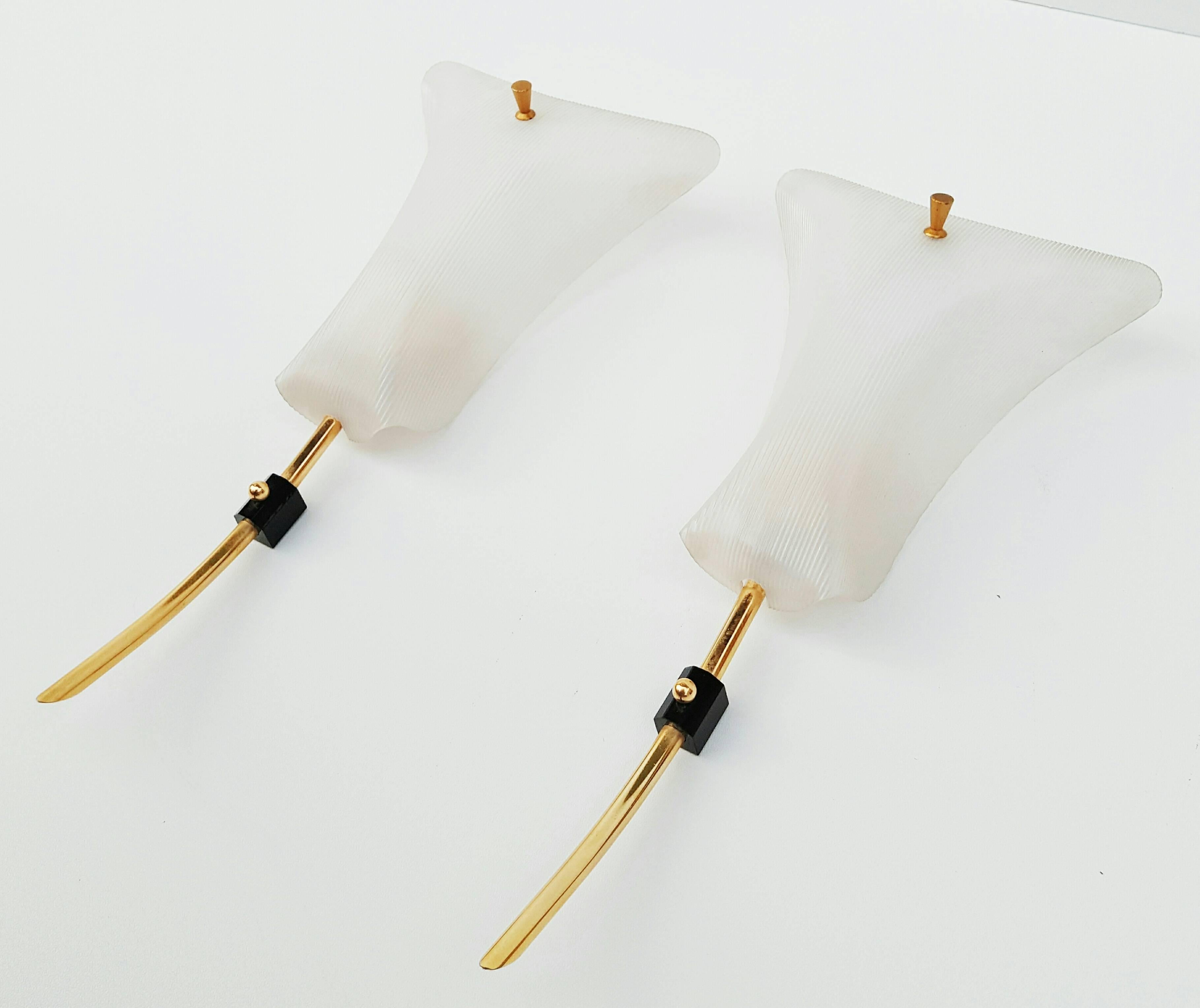 Delicate pair of 1950s Italian sconces with strilled plexi and brass detailing. The large plexi cones are cased on the inside and strilled front to give a very soft glowing light.