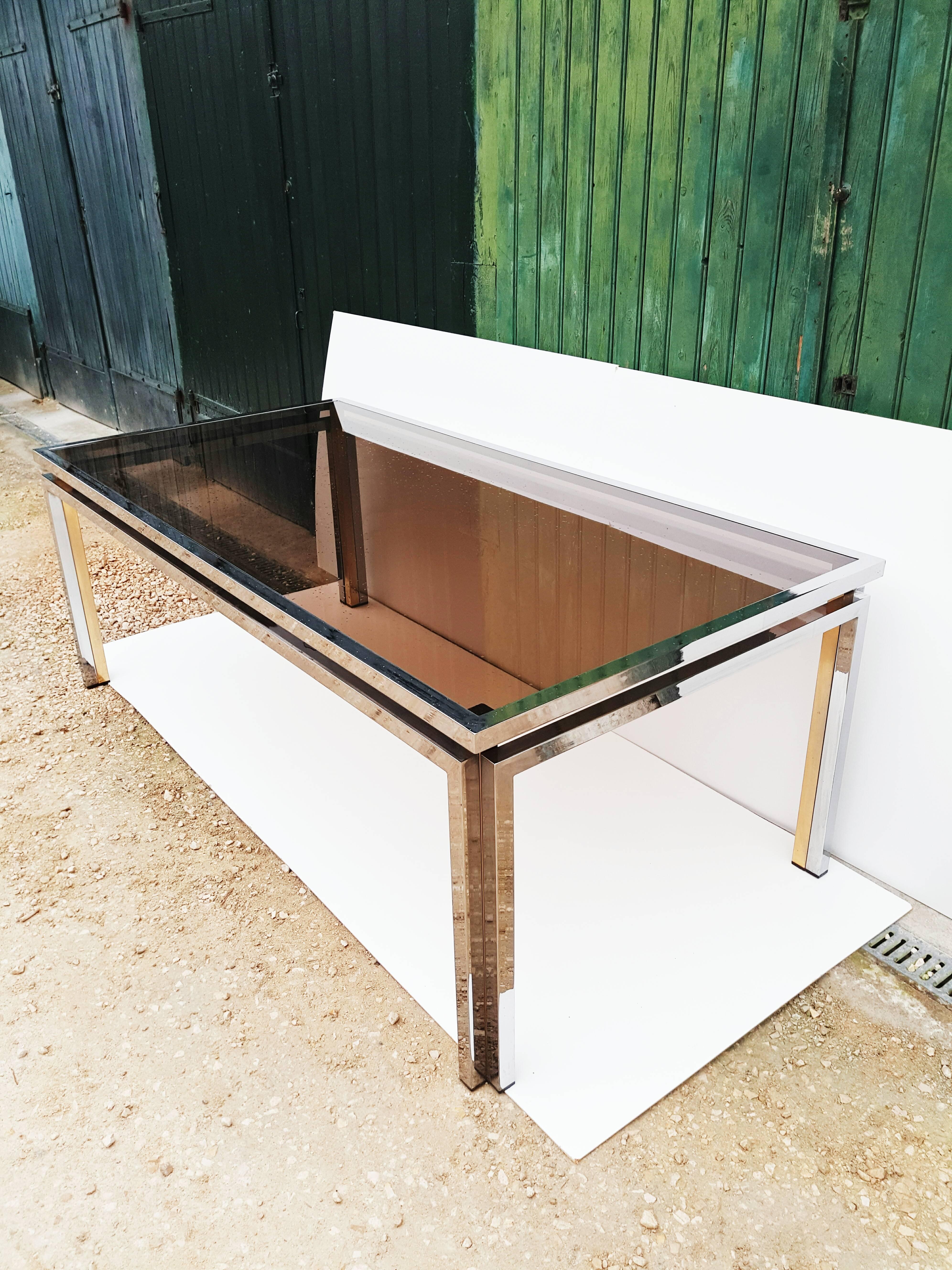 Superb Italian 1970s modern dining table with floating smoked glass top by Romeo Rega. This superb table could also make a super dramatic writing desk or library table.
The original smoked glass top has a bronze mirrored edge that adds depth and