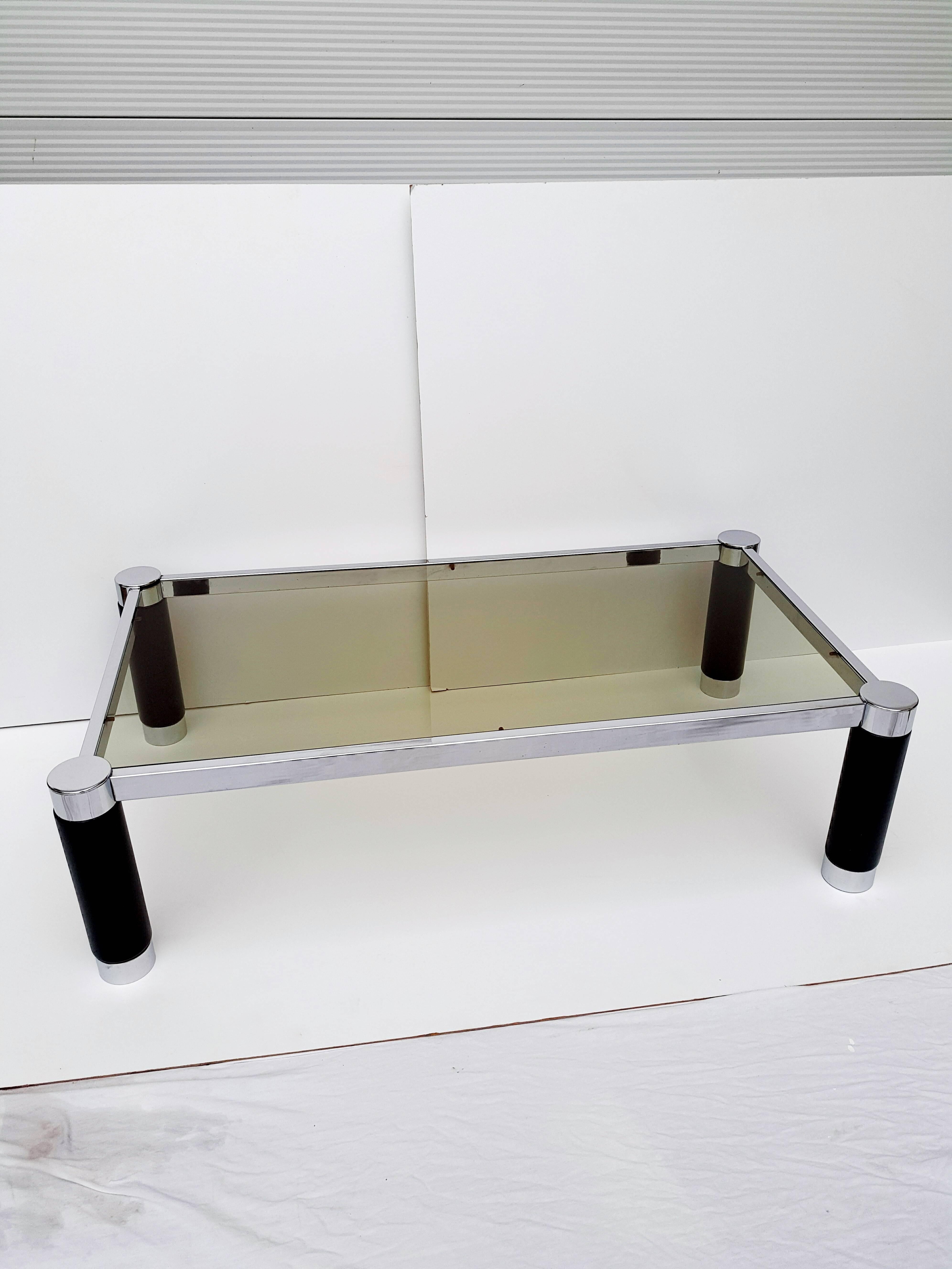 This coffee table by Roche Bobois is produced in France during the 1970s.
Rectangular with four large chrome and black lacquered wood leg and a dark smoked glass top. 
In excellent vintage condition.