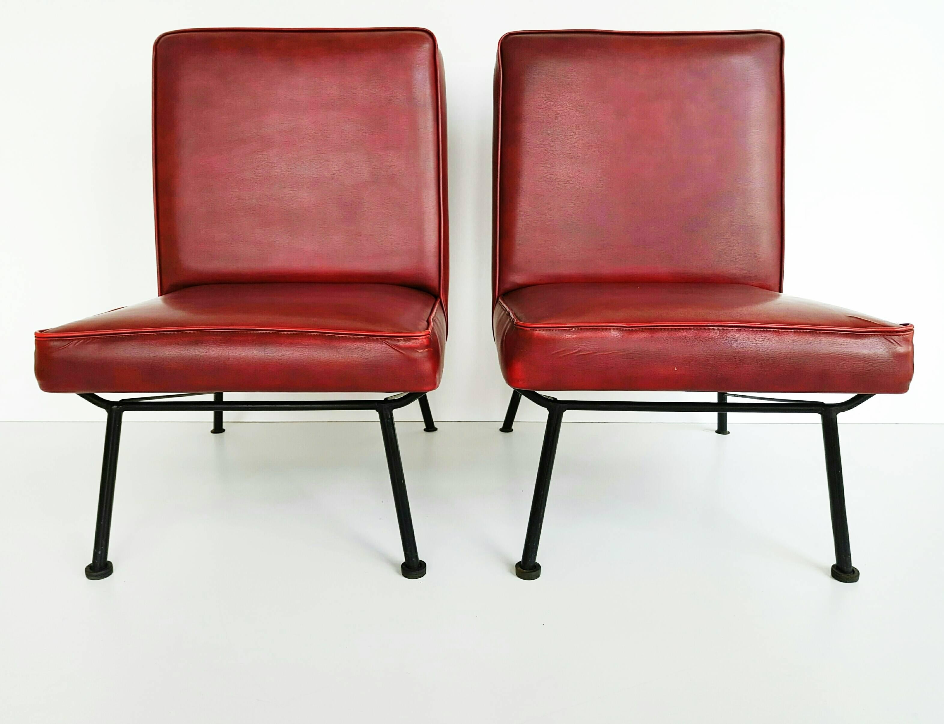 Beautiful pair of French lounge chairs manufactured in 1950s, with is original burgundy leatherette, in very good vintage condition. Very nice iron base.