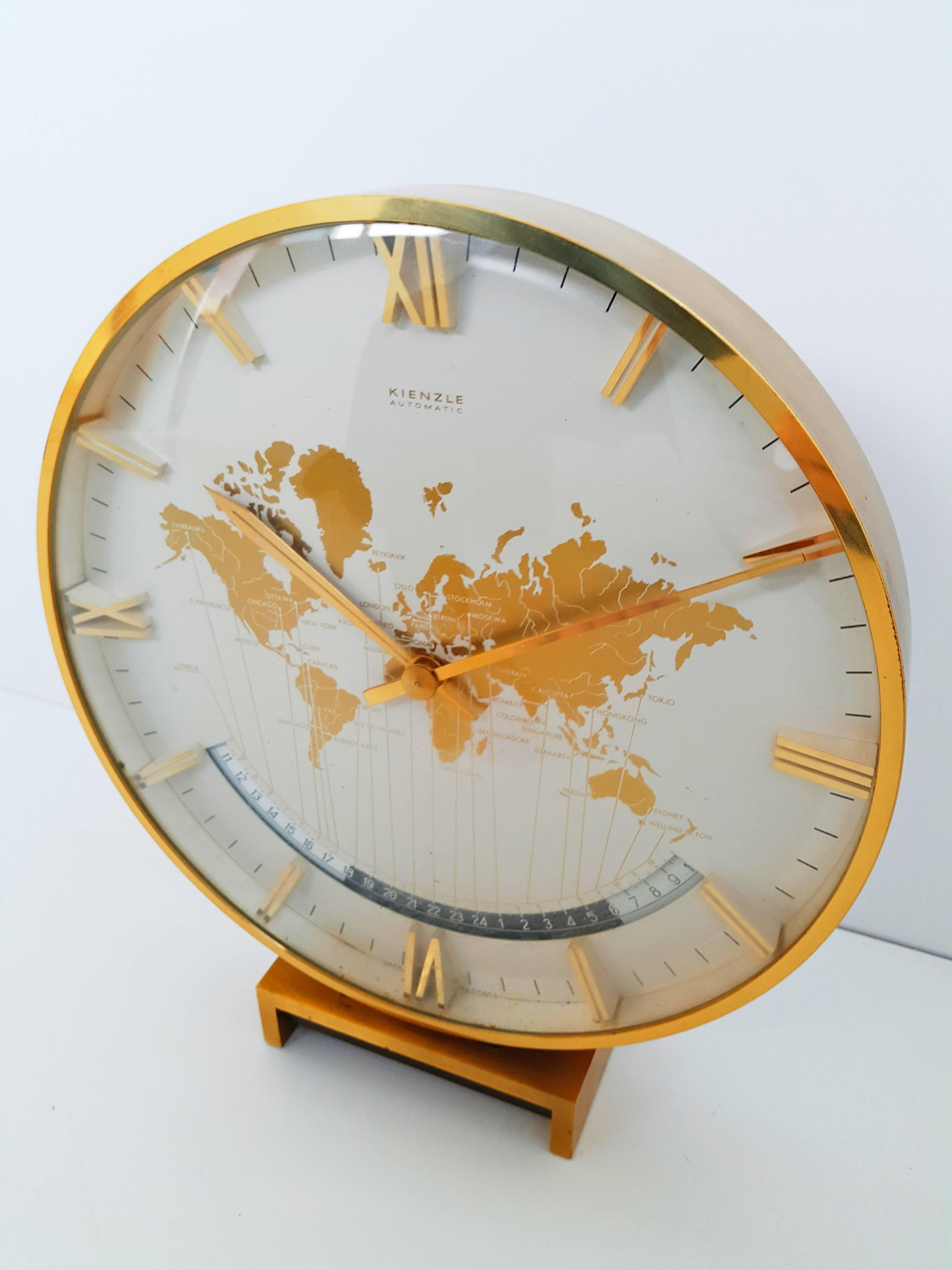 Kienzle automatic world timer zone clock. An exclusive big table clock from Ø 26cm wonderful clocks face with world map and world time zones, crystal glass, the heavy case and base are of solid brass. Battery movement. The most of Kienzle Clocks