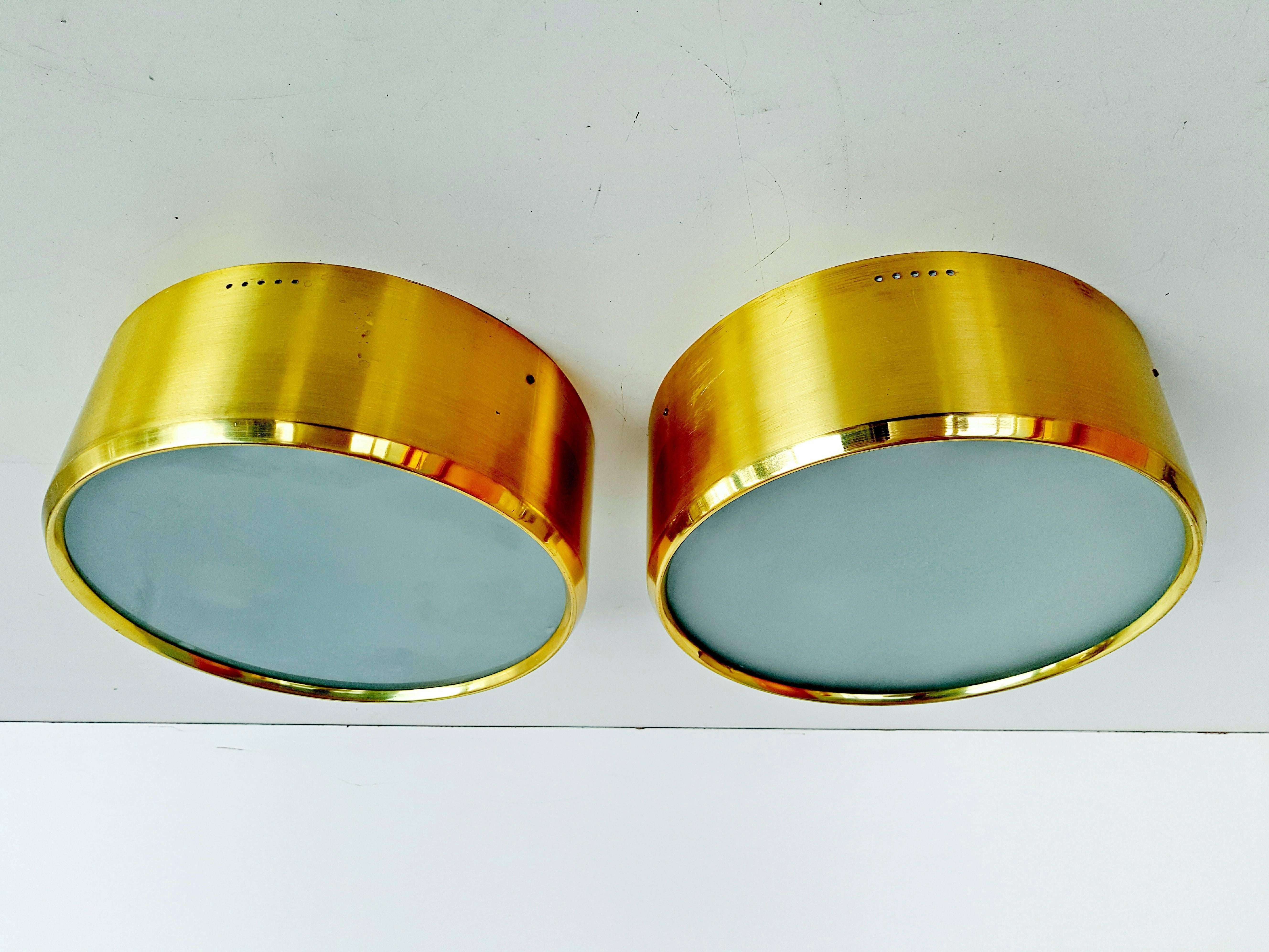 Rare pair of ceiling/wall lights manufactured by Stilnovo in Italy, circa 1960s. Brass, painted aluminum and textured glass. Two bulbs per sconce.