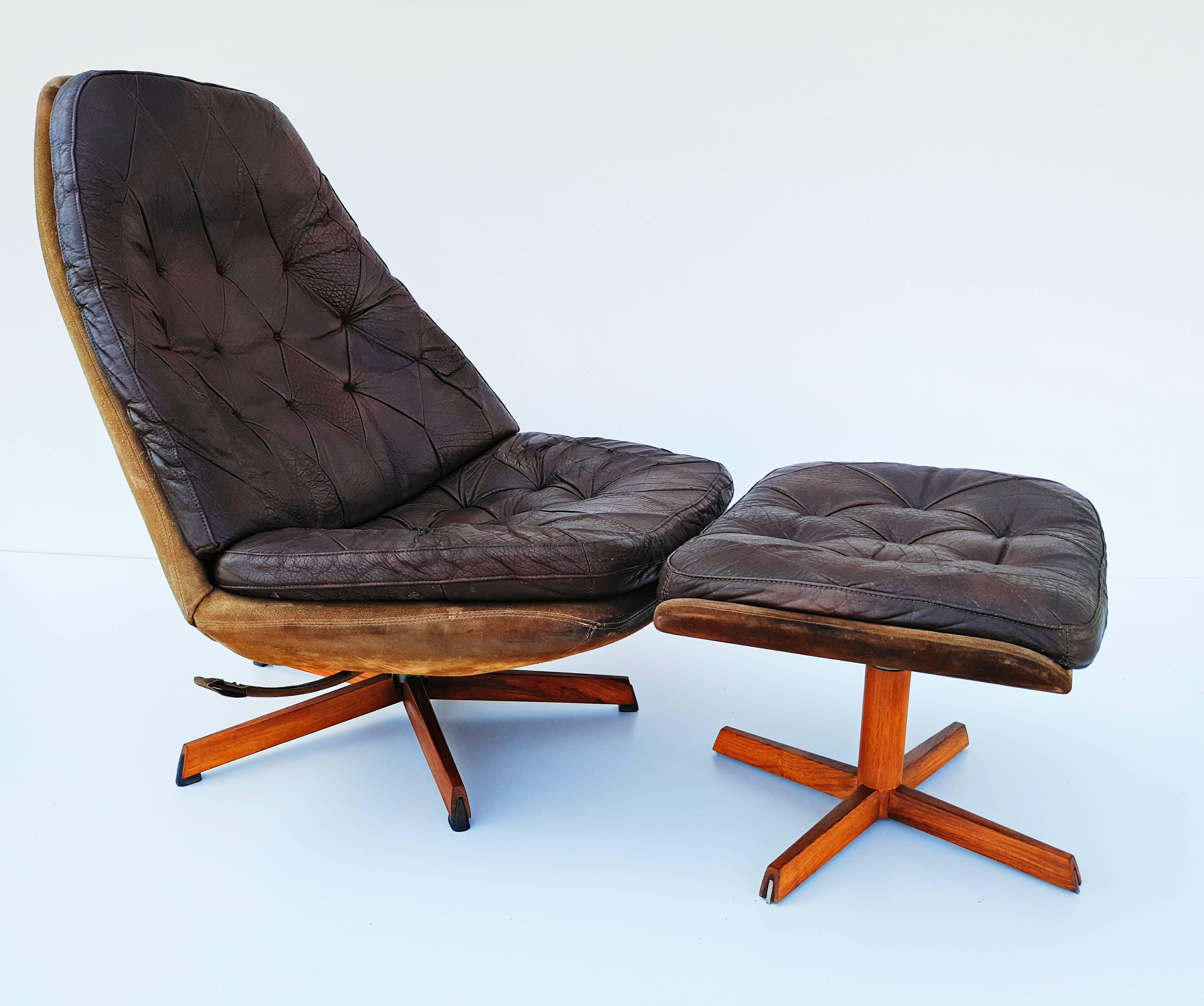 Could well be the Rolls Royce of swivel lounge chairs. Solid construction with top grain aniline leather on a base of steel and teak. Both chair and foot stool has tilting mechanism. 
Dimension ottoman(cm): 45 D x 57 W x 36 H.