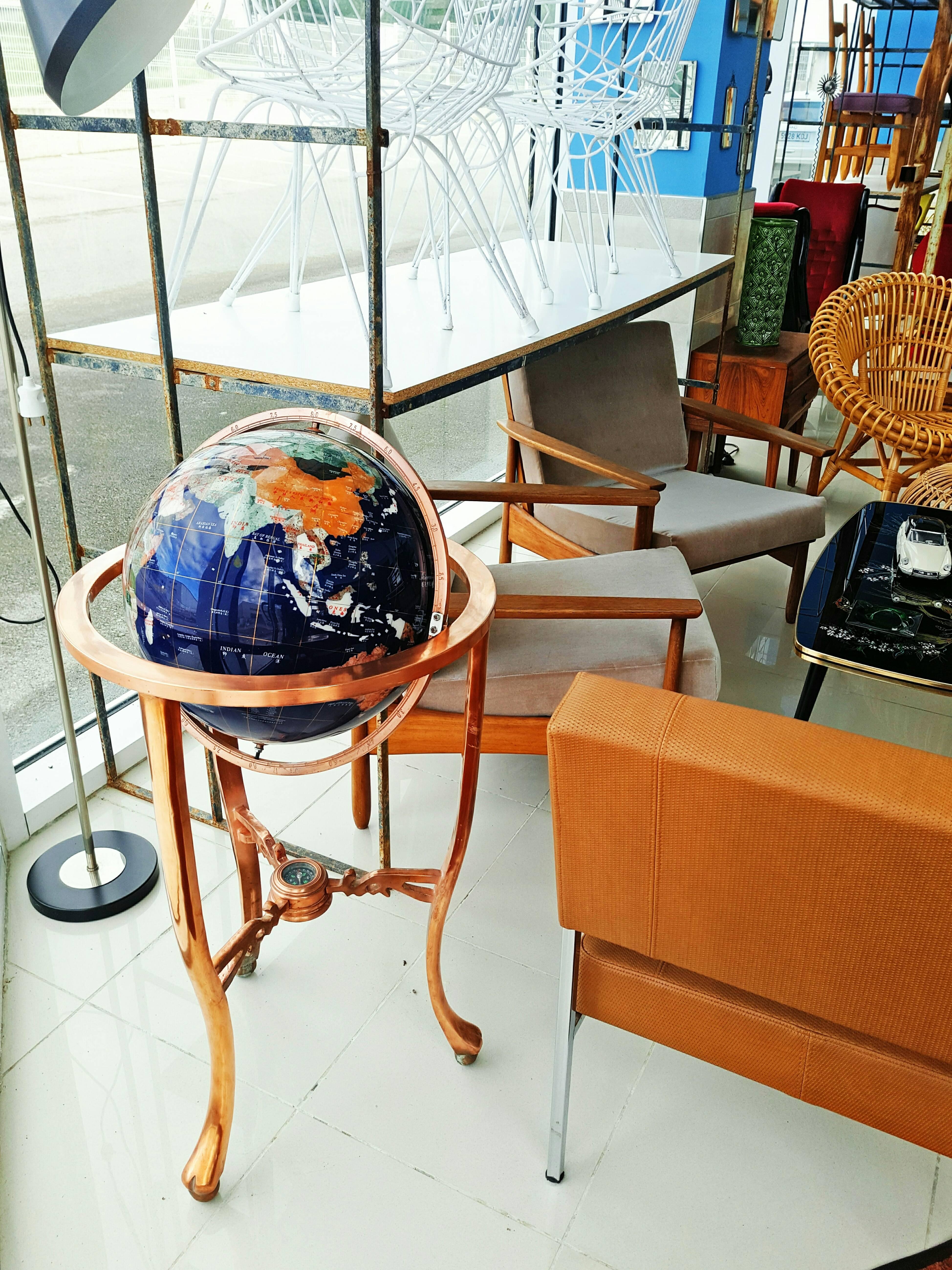 A massive three leg copper floor stand holds this magnificent Blue Lapis Gemstone Globe. Oceans of rich, ground Lapis Lazuli surround a mosaic of colorful gemstone continents, dramatic brass latitude and longitude lines complete the look. An