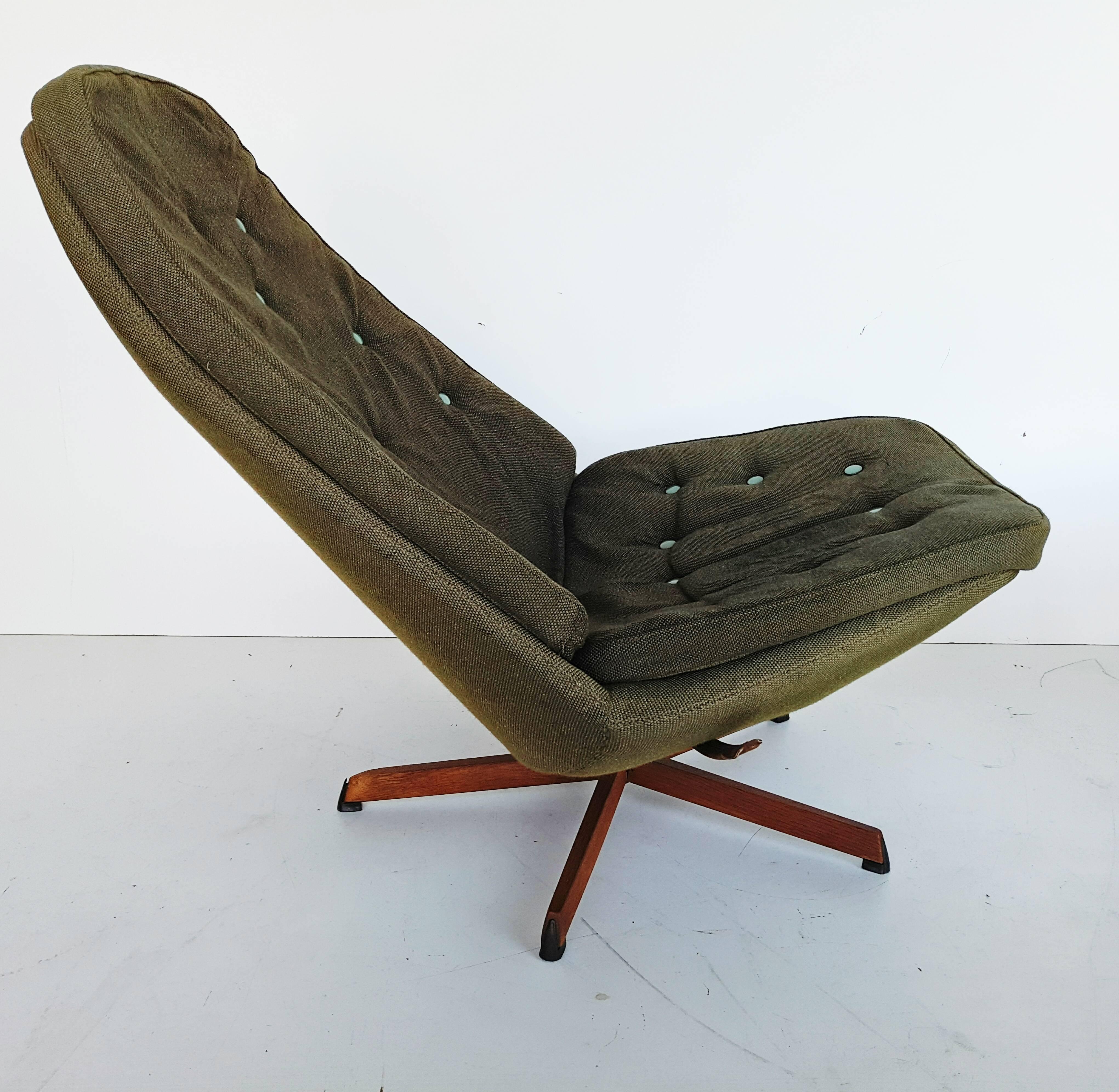 Could well be the Rolls Royce of swivel lounge chairs. Solid construction with top dark green original fabric on a base of steel and teak. Both chair and foot stool has tilting mechanism. Dimension ottoman (cm): 45 D x 57 W x 36 H.