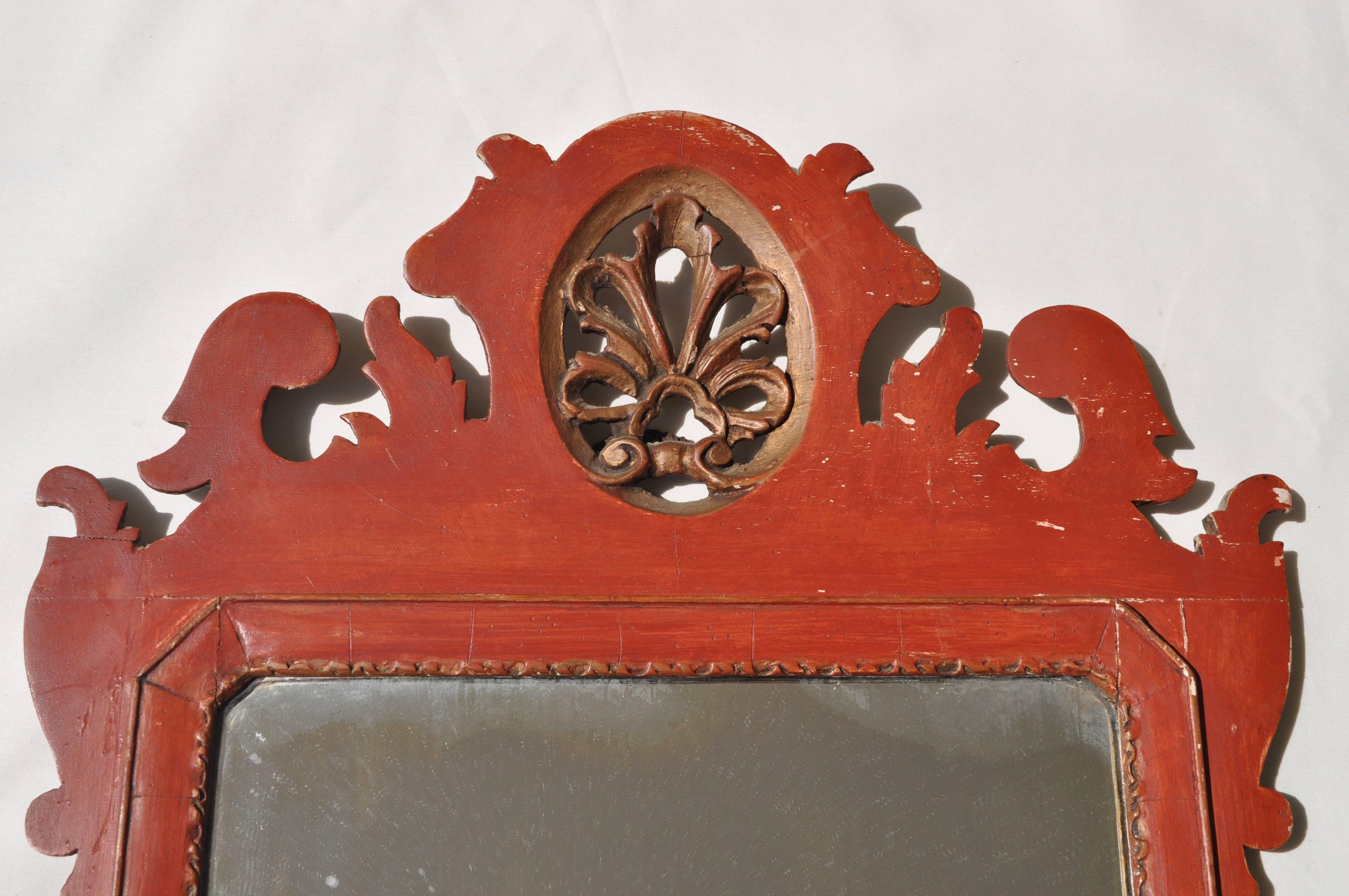 A beautiful carved and highly decorative 18th century mirror with original dark ochre and gold paintwork. The mirror has a date, a crest and initials carved on the back - '1742' 'A H W' 'London', as shown in the photographs.