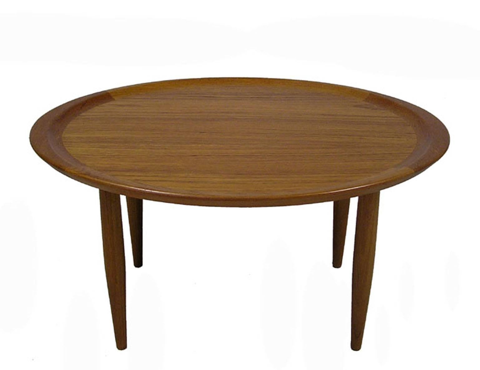 A gorgeous teak occasional side table from the 1960s Danish Modern era. Quality craftsmanship throughout featuring a thick solid teak band and tapered conical legs. Overall excellent condition.