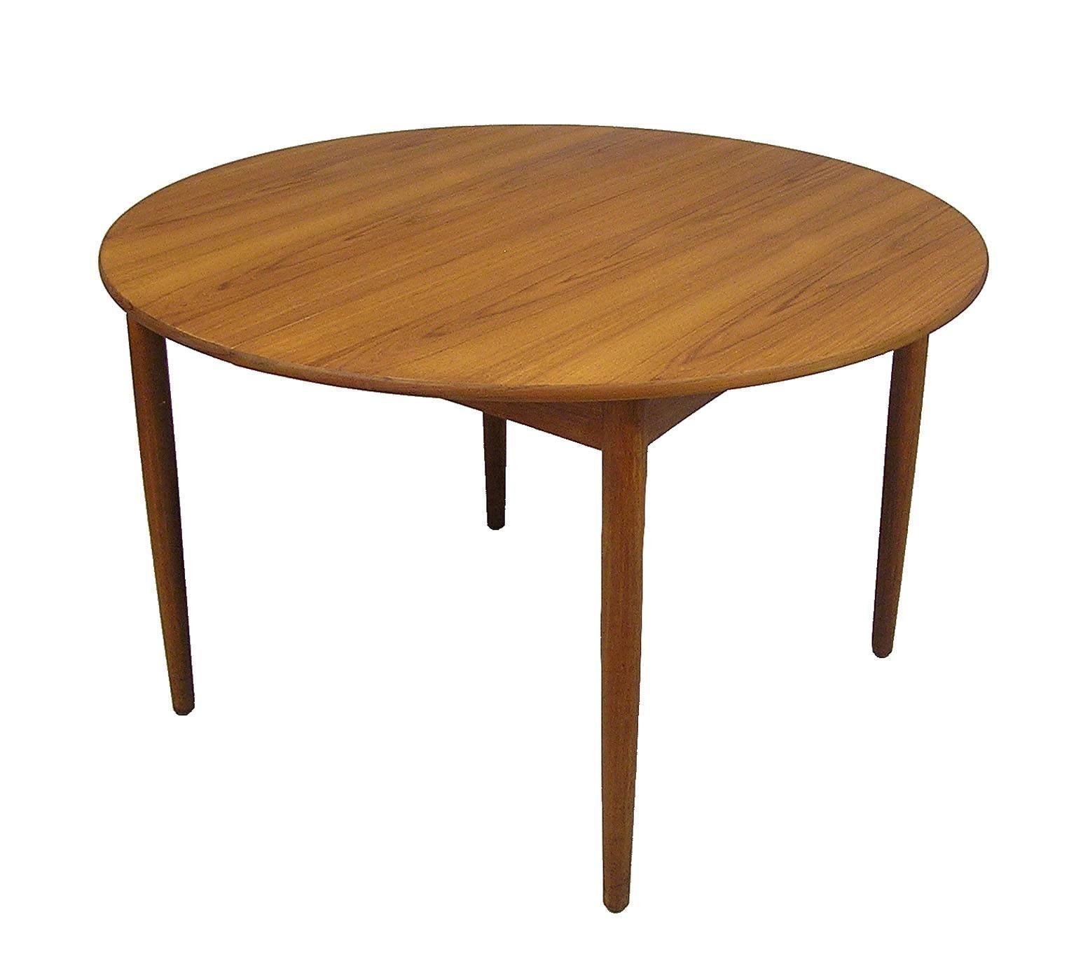 A stylish round teak dining table from the 1950s Mid-Century Modern era by Børge Mogensen for Soborg Mobelfabrik of Denmark. Designed in 1952 the model 121 dining table was one of Mogensens earlier designs and comes with an additional 23 1/4