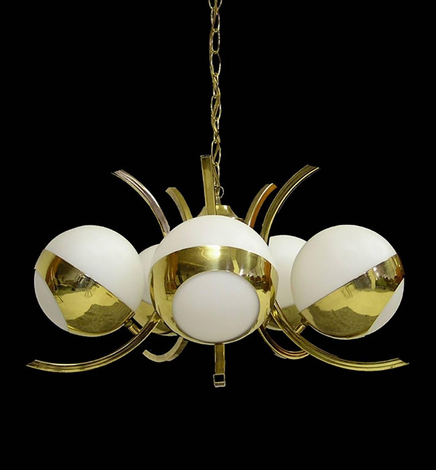 A stunning five-light brass chandelier from the 1970s by Stilnovo of Italy. Well constructed and designed featuring arced brass arms that support the elliptical brass supports for the frosted glass globes. Operates via a switch located on the 13'