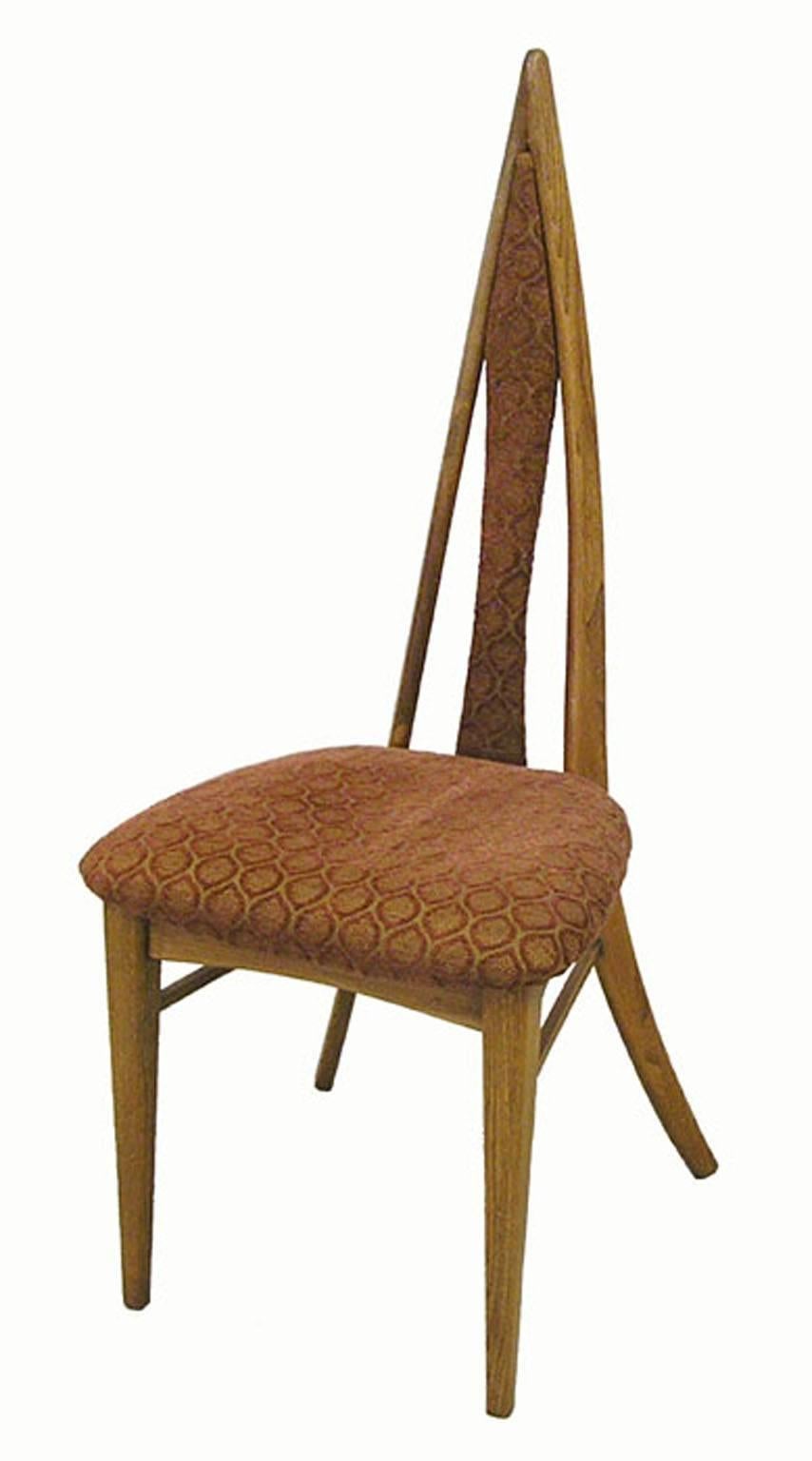 A unique set of four ash dining chairs from the 1950s Mid-Century Modern era by Canadian cabinetmakers Danis et Freres of Granby, Quebec. Beautifully crafted featuring a solid sculpted ash frame with a narrow steepled backrest and sprawled back