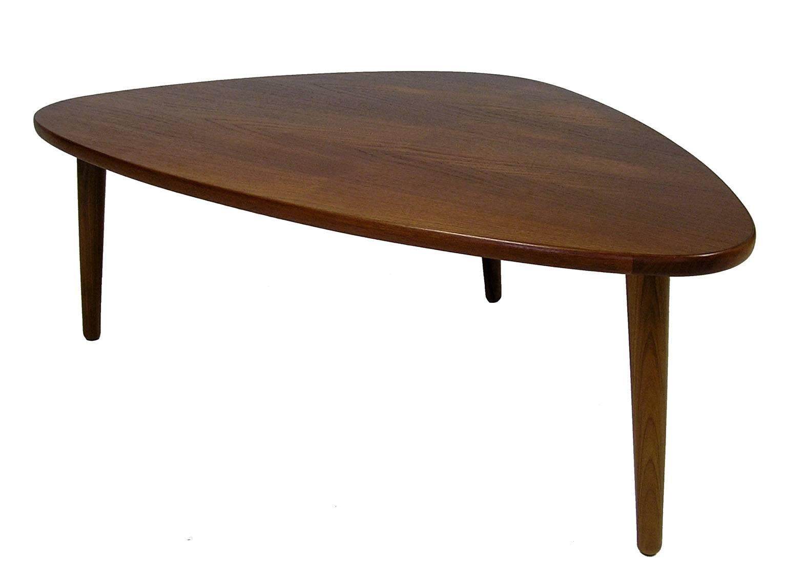 A stylish teak coffee table from the 1960s by Anton Kildeberg Møbelfabrik of Denmark. Features a unique organic form with tapered conical legs and tons of Mid-Century Modern era character. Overall excellent condition with makers marks on the