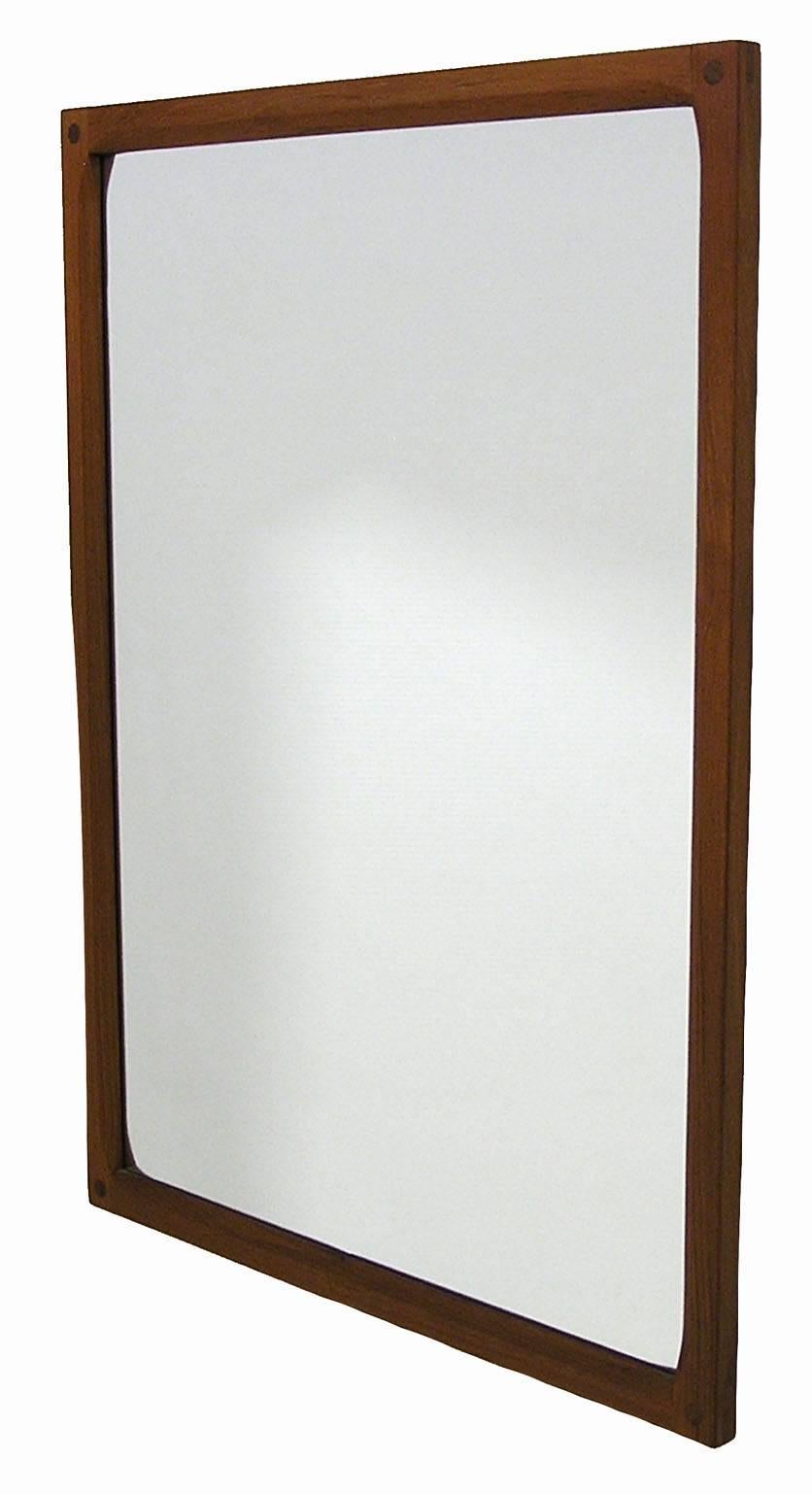 A beautiful teak wall mirror from the 1960s Mid-Century Modern era by Aksel Kjersgaard of Denmark. Gorgeous craftsmanship throughout featuring a solid teak frame with a sculpted inner edge and attractive corner joinery. Excellent condition.