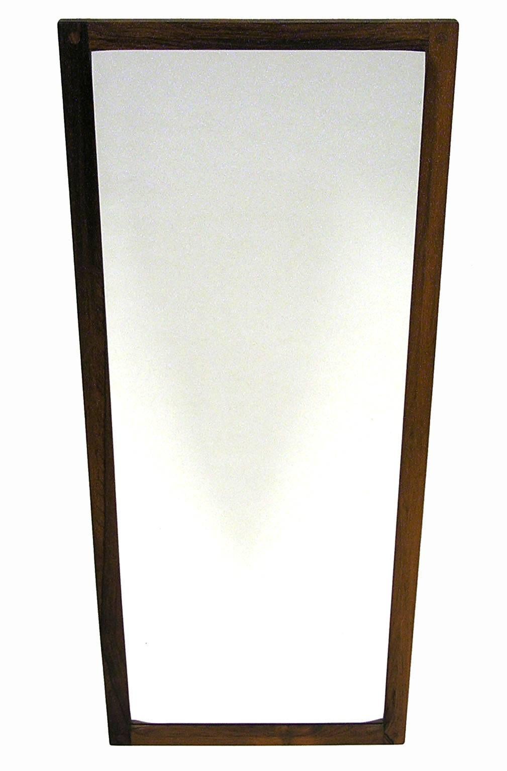 A gorgeous rosewood wall mirror from the 1960s Mid-Century Modern era by Aksel Kjersgaard of Denmark. Features a solid rosewood frame with a sculpted inner edge and attractive corner joinery. Frame is in excellent overall shape. Upon close