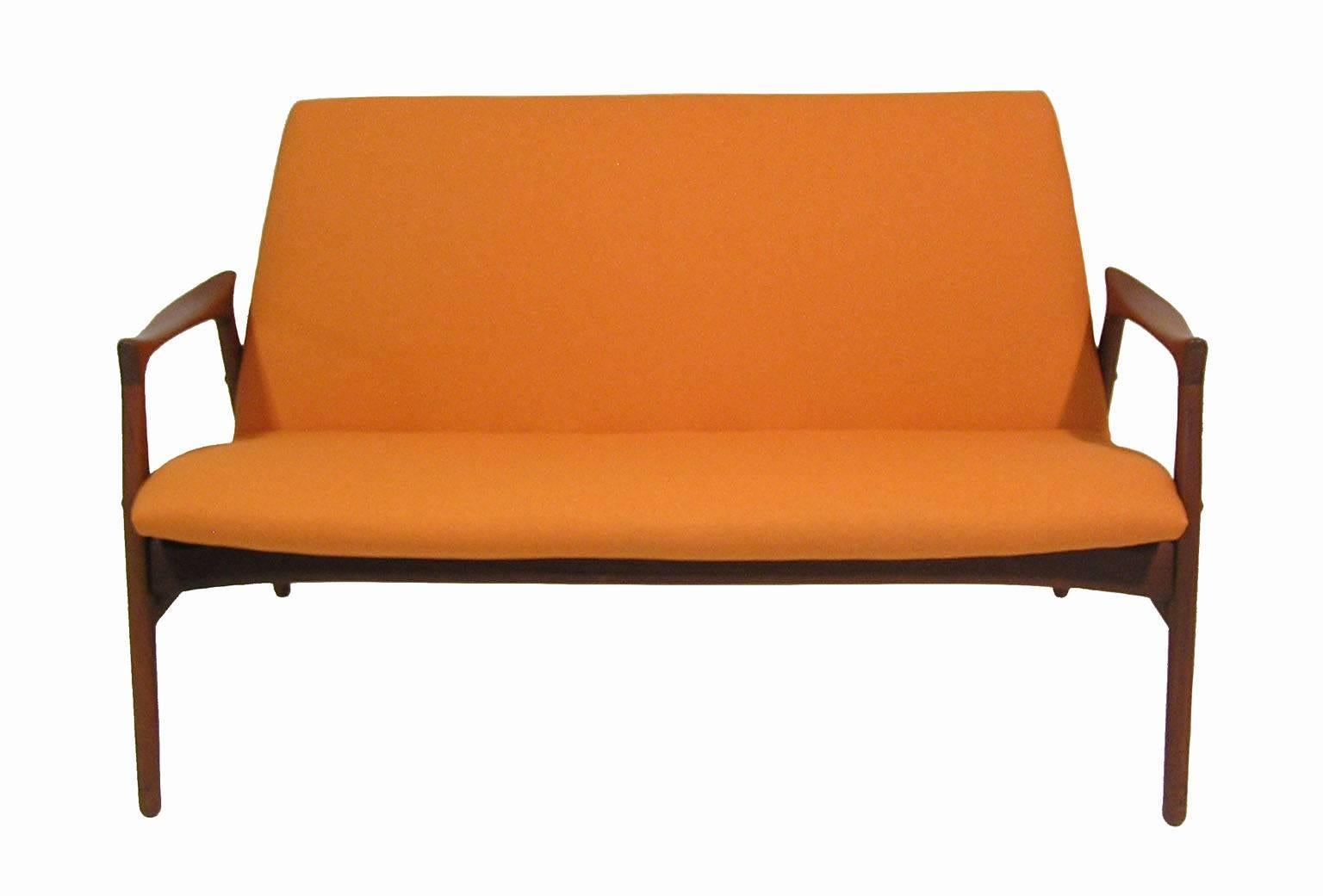 A stylish teak settee from the 1950s Danish Modern era by Hans Olsen of Denmark. Amazing craftsmanship throughout featuring a beautifully sculpted solid teak frame. Newly reupholstered in a orange fabric material and in overall excellent condition.