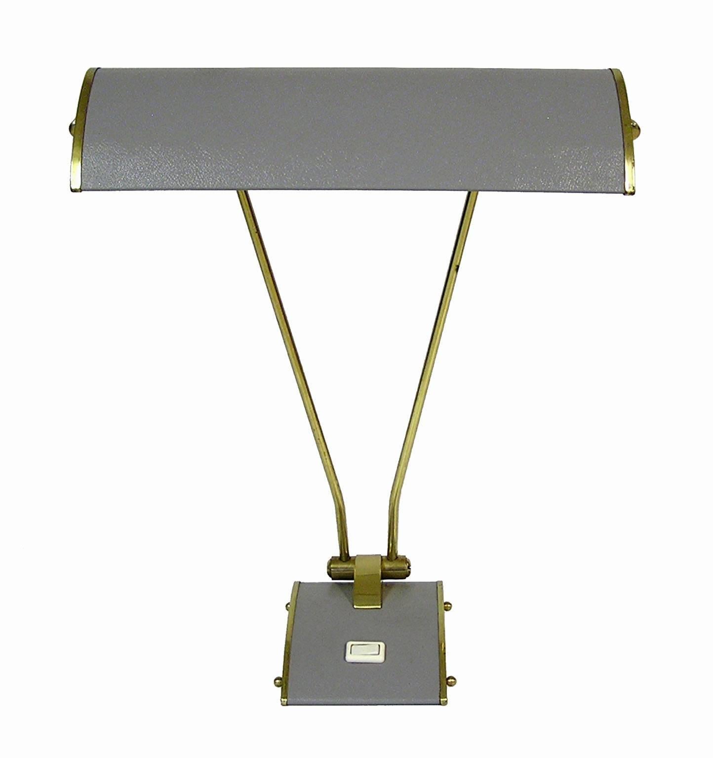 A beautiful desk lamp from the 1940s era designed by Eileen Gray for Jumo of France. Constructed out of brass and metal with and adjustable shaft and hood. Lamp is fitted with Dual light sockets and while it still has the original switch located on
