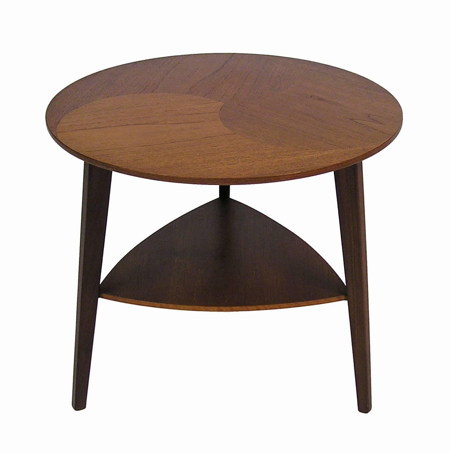 A rare tripod-leg teak occasional table from the 1960s Danish Mid-Century Modern era. Beautiful craftsmanship throughout featuring a round biomorphic designed top with lower shelf and tapered legs. Stamped 