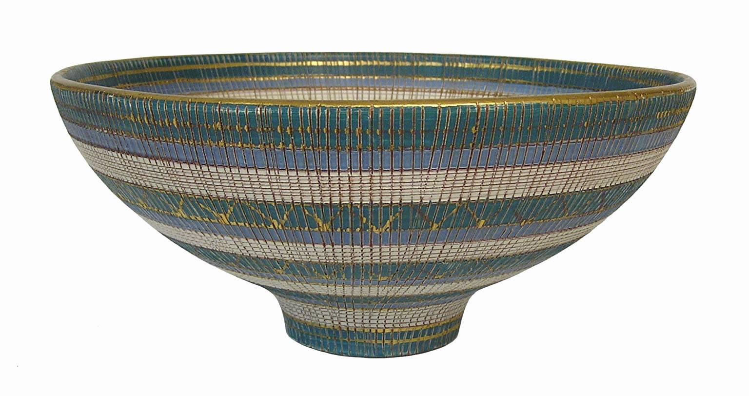 A gorgeous footed Sgraffito ceramic bowl from the 1960s by Bitossi of Italy. Produced as part of the 'Seta' series and decorated in a blue, white and turquoise glaze with gold accents. Signed on the bottom and in overall excellent condition.