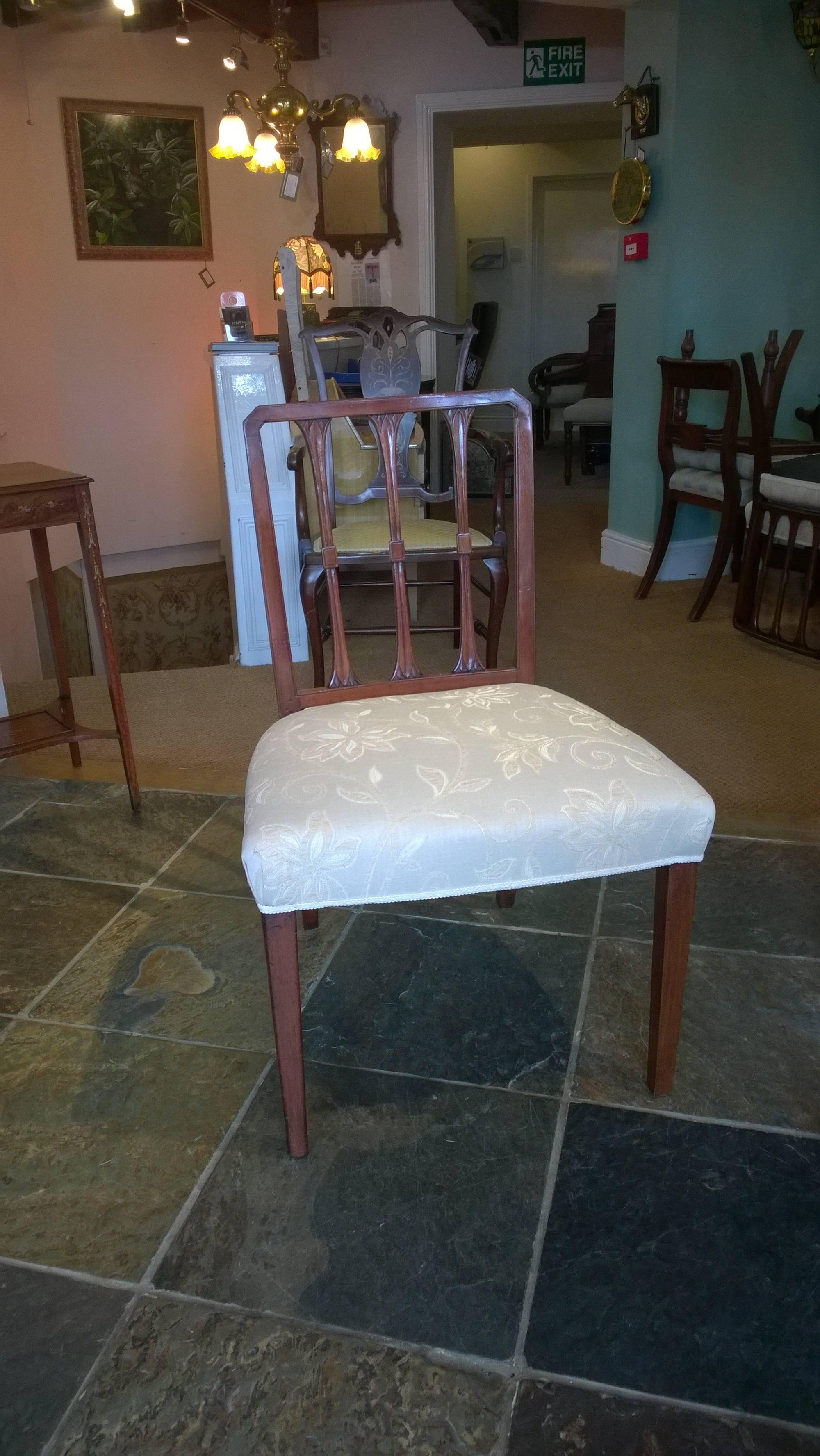 Set of eight Georgian mahogany dining chairs with vertical bar backs over stuffed upholstery on square tapered legs, circa 1780. Measures: 21