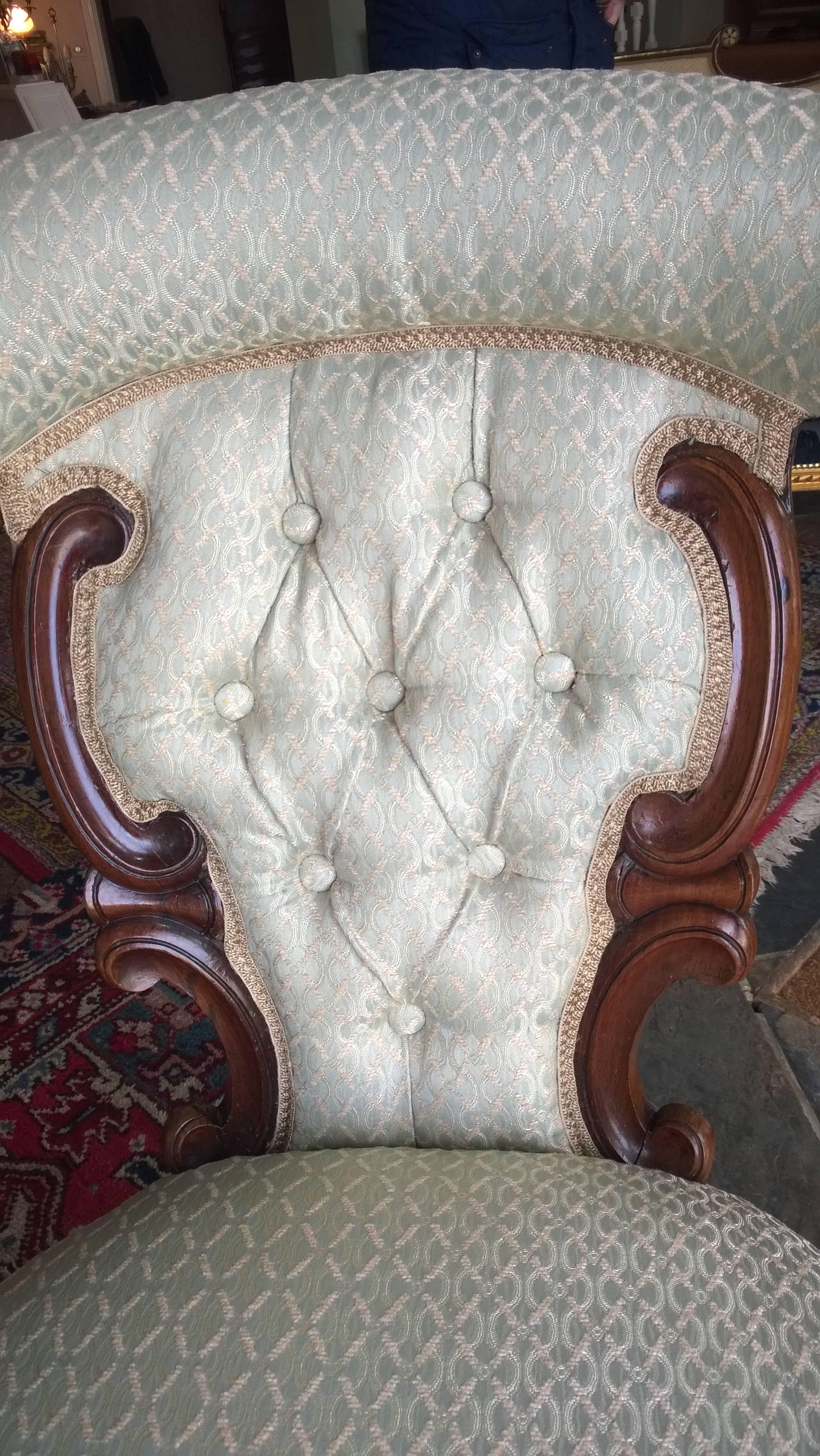 Victorian carved rosewood framed upholstered open armchair with cabriole legs and scroll feet measure: 21" W x 31" D x 34" H.