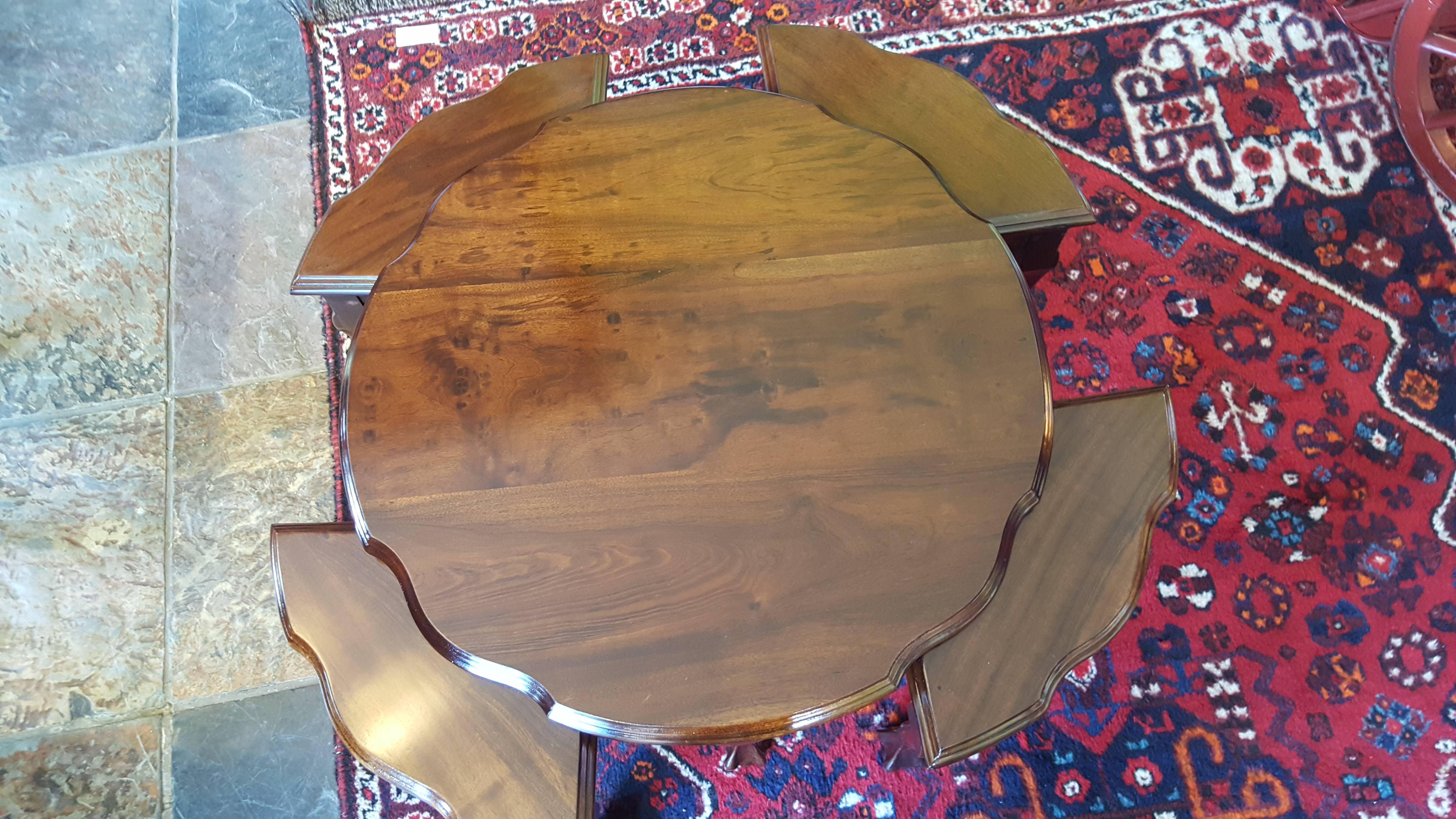 Mahogany nest of coffee tables with shaped circular top and four triangular nesting tables, circa 1930.