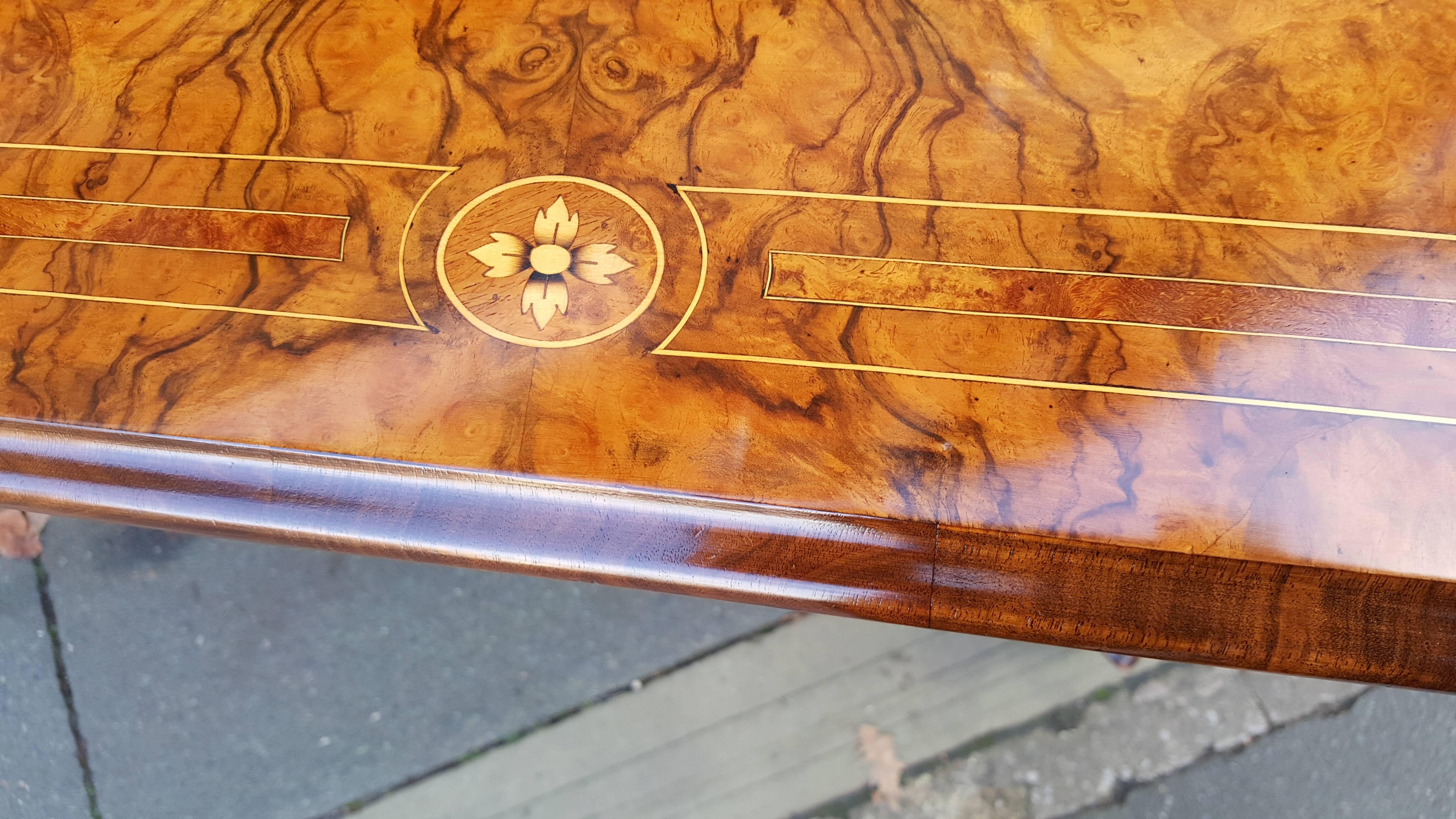 High Victorian burr walnut card table with quarter veneered top Inlaid with satinwood and rosewood, turned pillaster supports on sabre legs and pad feet with porcelain castors.
Measures: 38