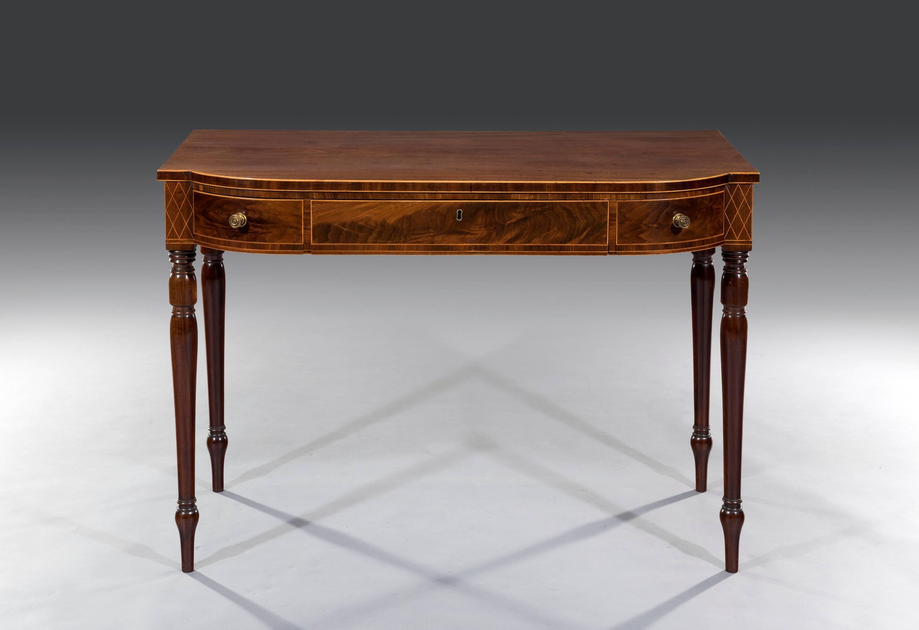 Late Georgian three-drawer bow fronted mahogany console serving table of Sheraton design with satinwood string inlay and turned legs.
Measures: 42