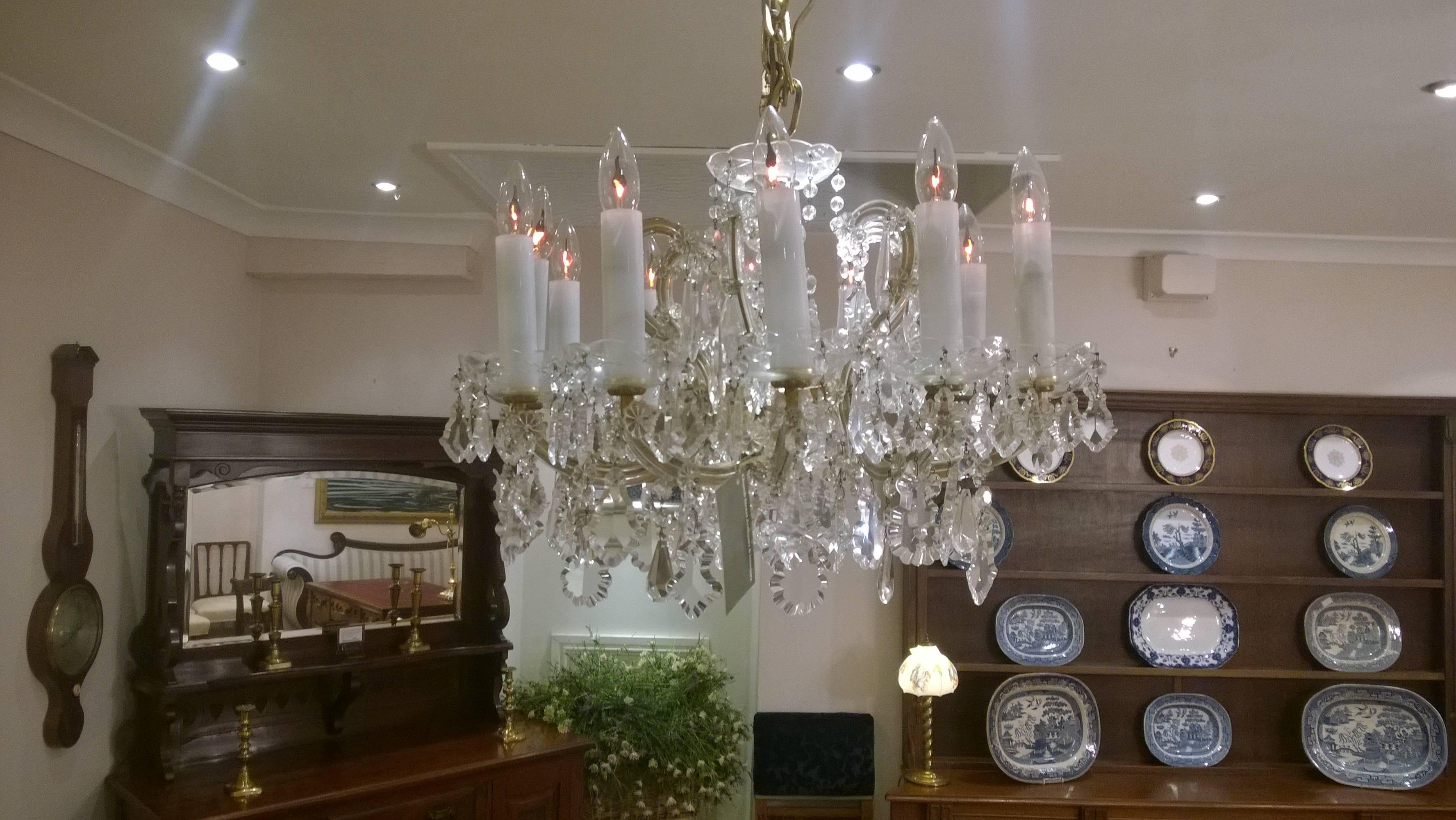 Twelve-arm chandelier with brass arms and body covered with pressed glass casings the whole decorated with Bohemian crystal drops circa 1920, all lights and lamps have been rewired with authentic corded flex, fitted with either foot switch or finger