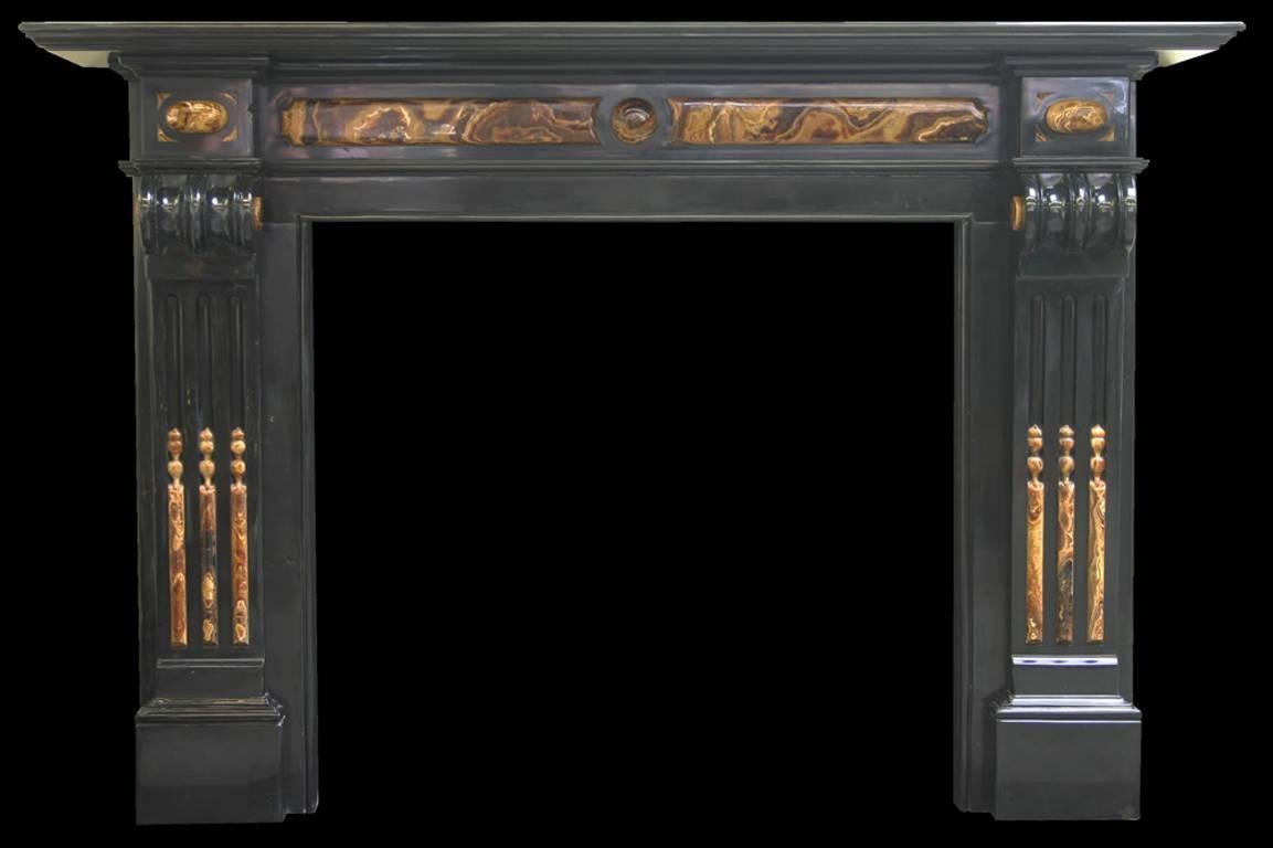 An unusual and imposing restored and polished Victorian Belgian black marble chimneypiece with carved corbels and fluted legs, the flutes decorated with onyx reeds. Onyx mounts and inlays to the frieze and capitals, circa 1890.
Measures: Shelf