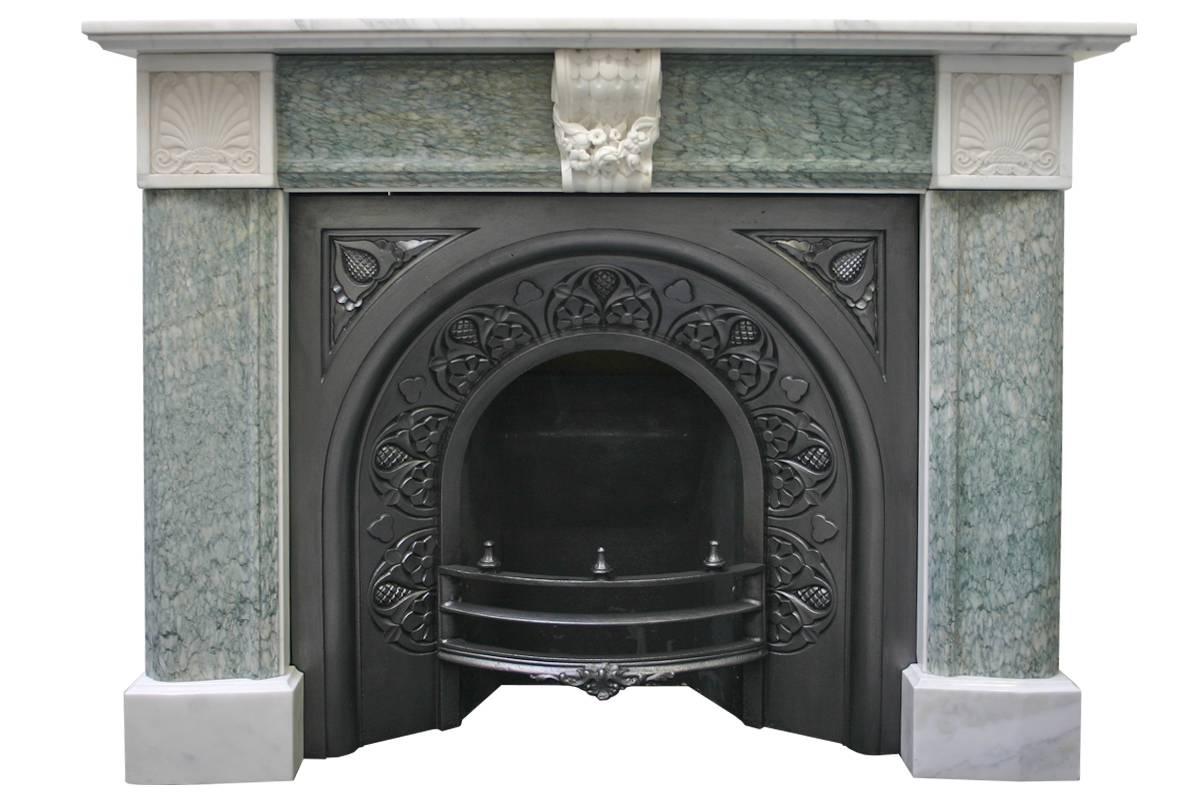 Antique 19th Century Regency marble fire surround. Plain statuary marble plinths support green Campan marble bolection jambs terminating in statuary marble end blocks carved with an anthemion design. The frieze is green Campan marble bolection